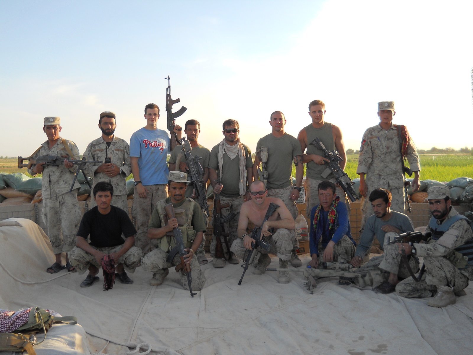 Fourth from the left, back row, Zabiullah Zyah, who worked as an interpreter for the US military in Afghanistan for less than two years between 2010 and 2012, is pictured with his a US Marines Sniper team and the Afghan National Security Forces at a checkpoint near the town of Marjah, Helmand province [Sayed Jalal Shajjan/Al Jazeera]