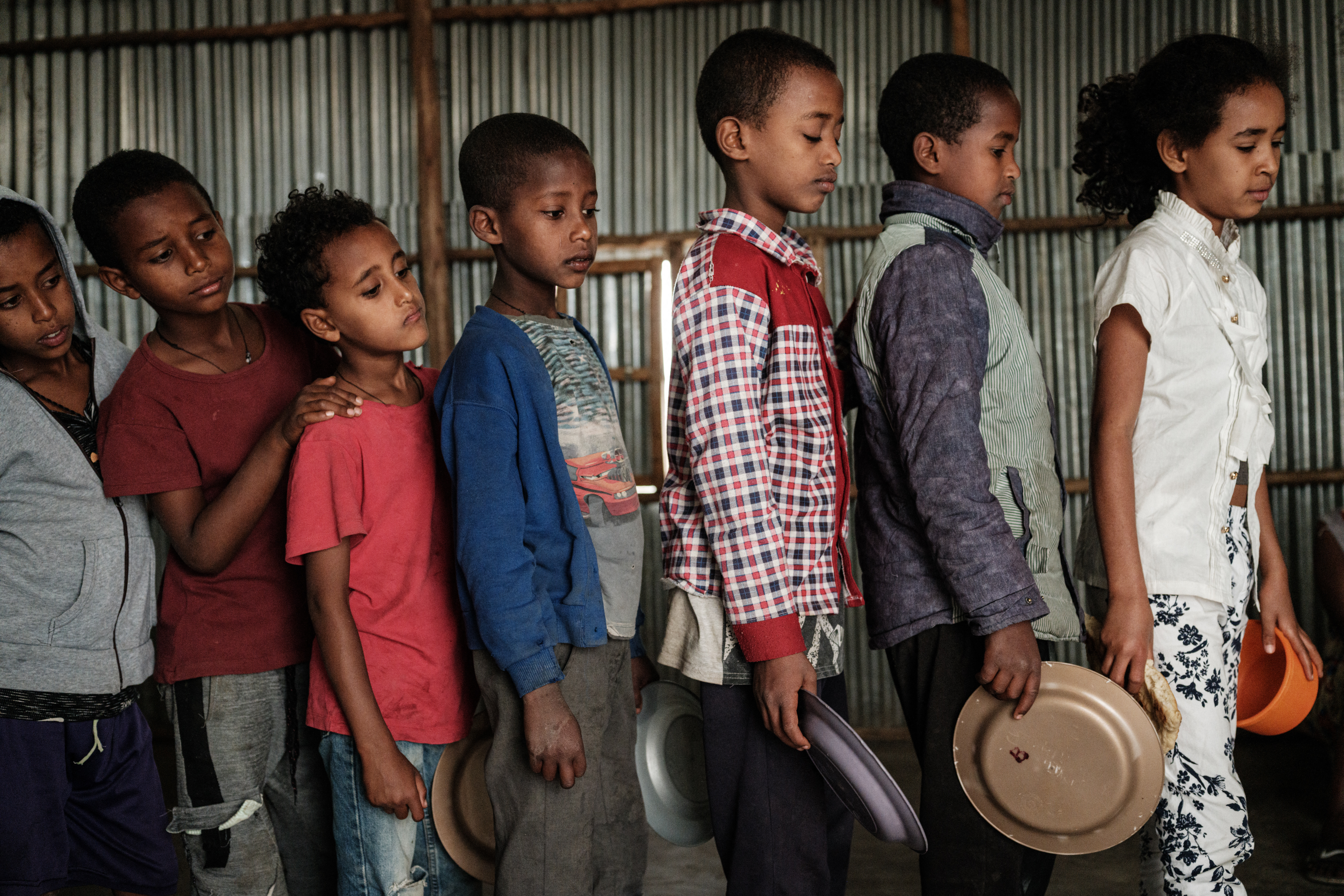 Children, who fled the violence in Ethiopia's Tigray region, wait in line for breakfast organised by a volunteer, in Mekelle, the capital of Tigray region, on June 23, 2021 [File: Yasuyoshi Chiba/AFP]