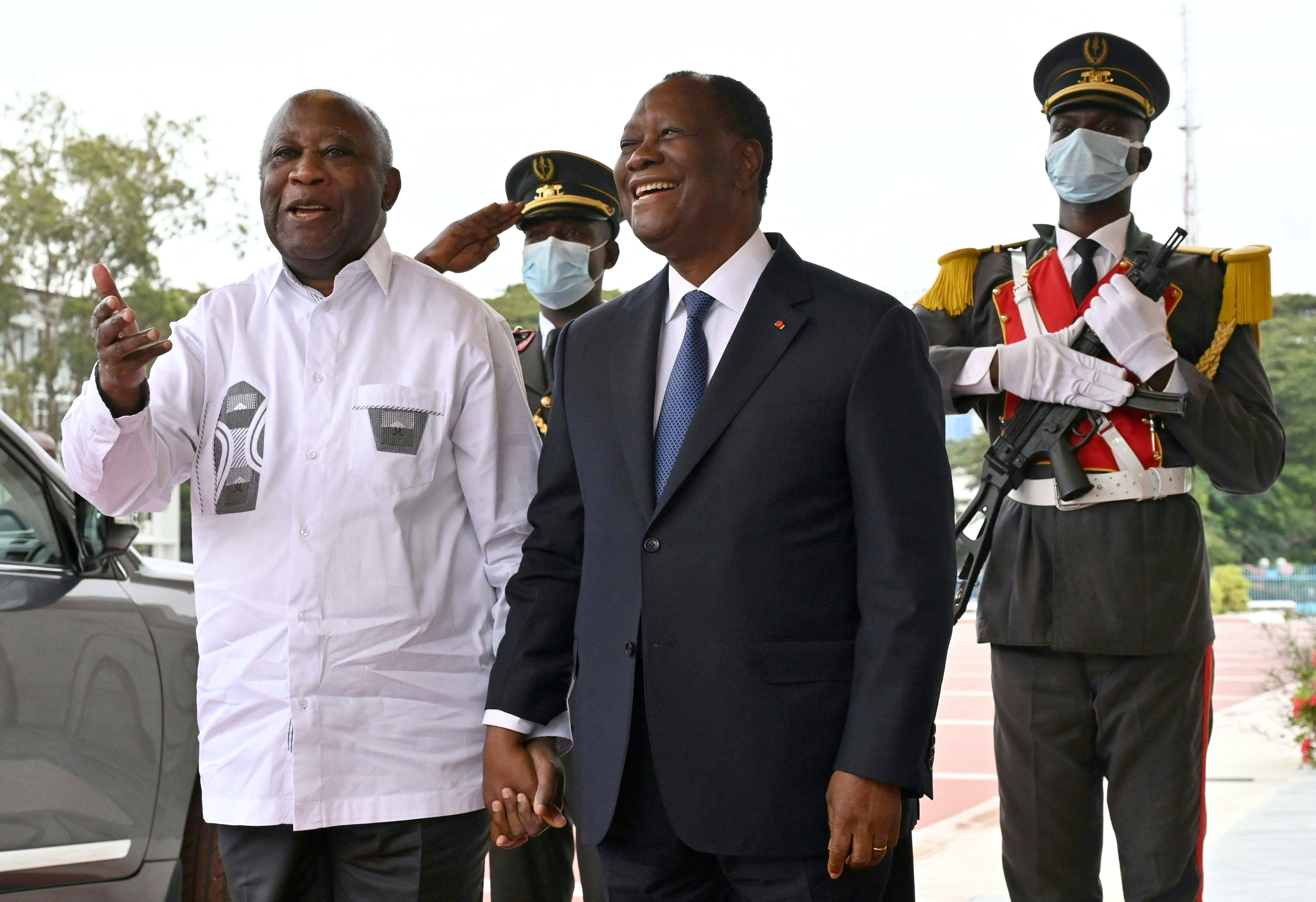 Ivory Coast President Alassane Ouattara (C) poses with former President Laurent Gbagbo (L) at the presidential palace in Abidjan