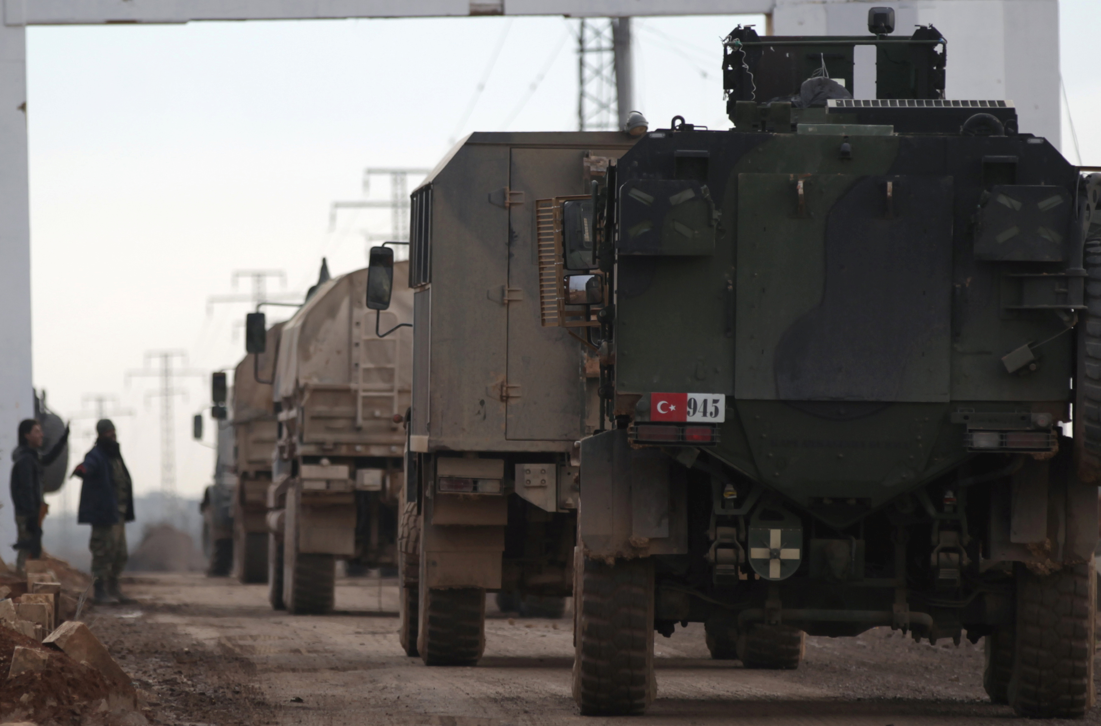 Free Syrian Army fighters gesture as Turkish military vehicles drive in the Syrian rebel-held town of al-Rai while heading towards the northern Syrian town of al-Bab, Syria January 9, 2017.