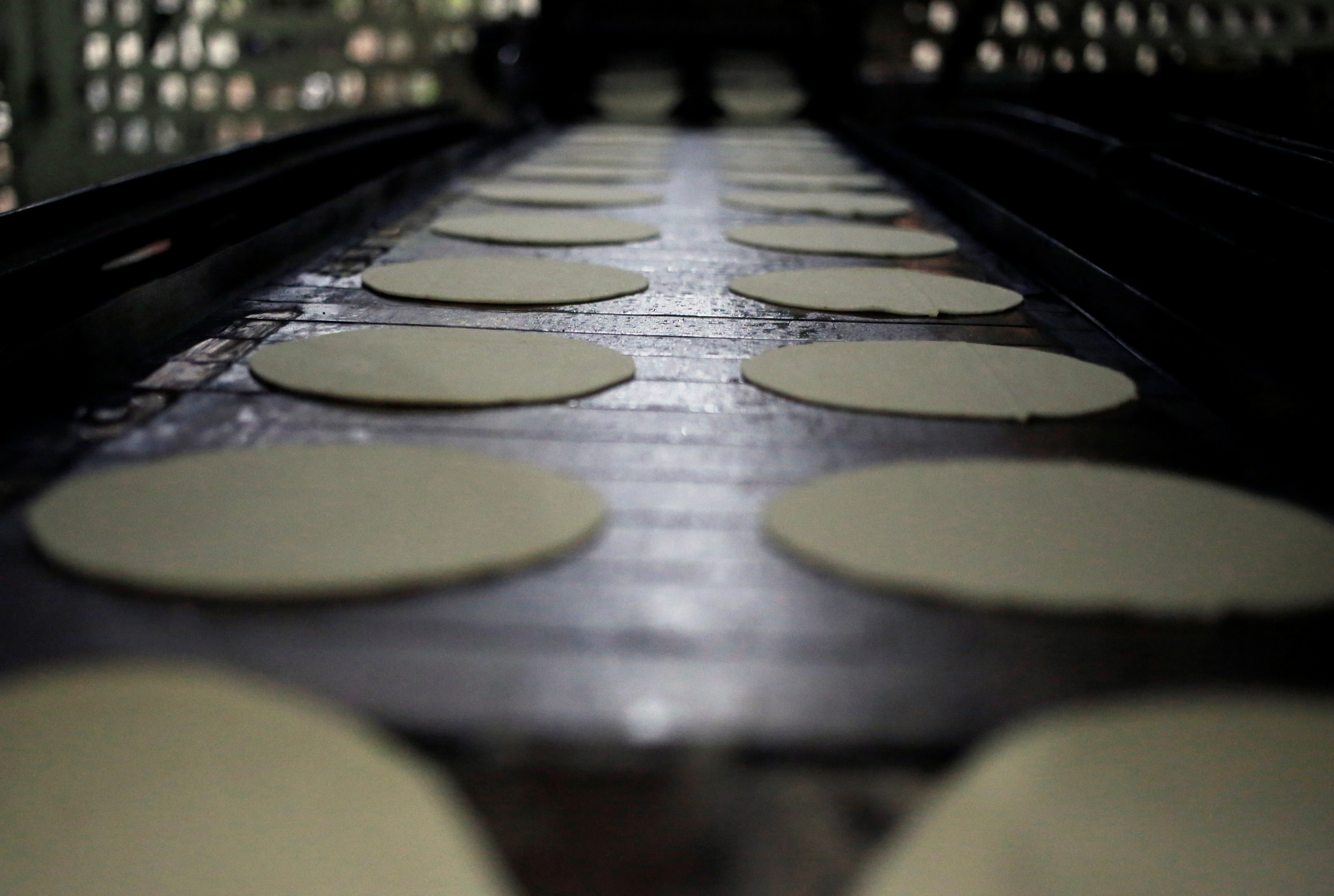 A view shows tortillas in preparation to be wrapped in paper with contact information to help women victims of gender violence, as a part of a government program called "Break the Silence", at a tortilla stall in Nuevo Laredo, Mexico, March 10, 2020. [Daniel Becerril/Reuters]