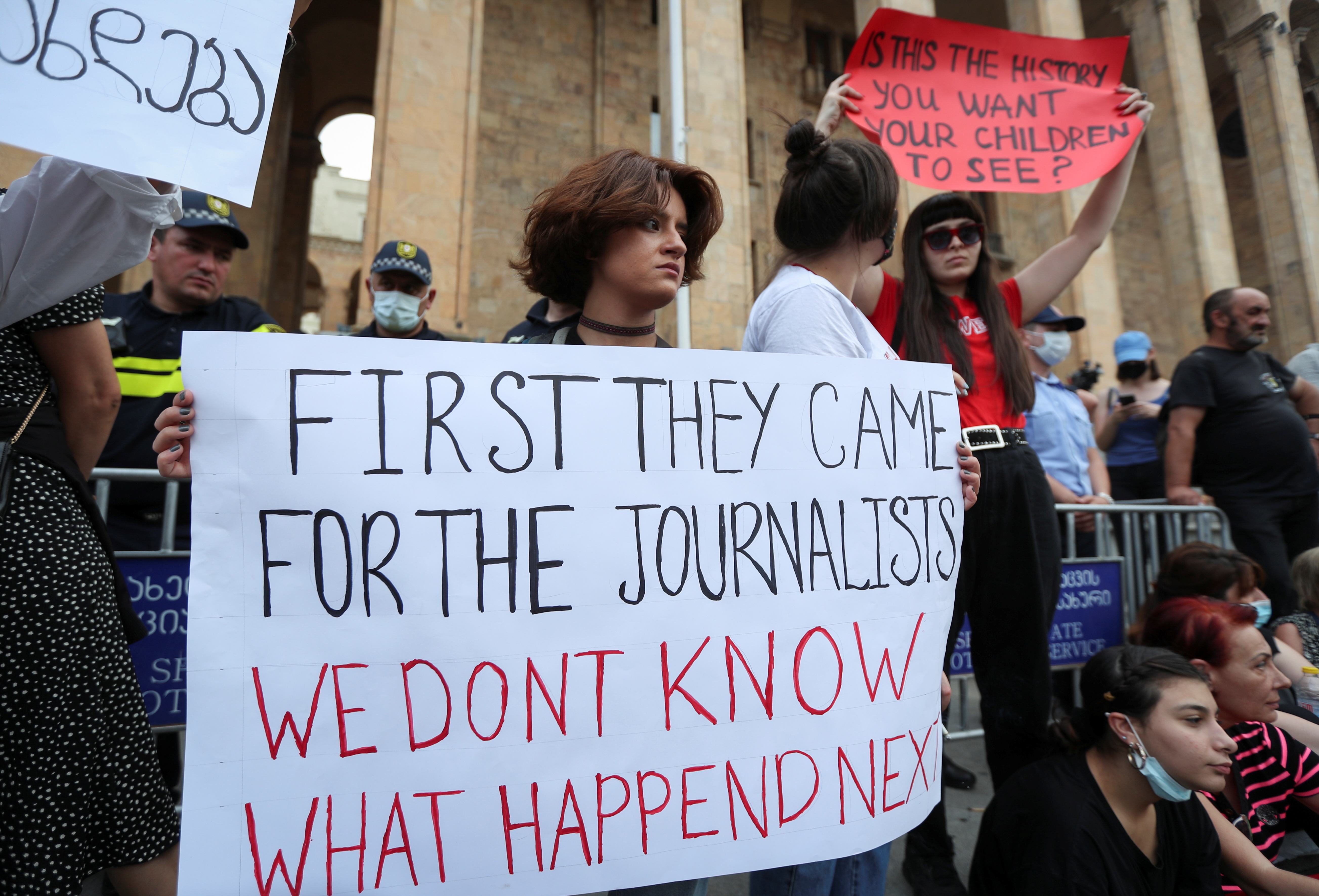 Activists hold posters during a rally in memory of Pirveli TV channel cameraman Alexander Lashkarava