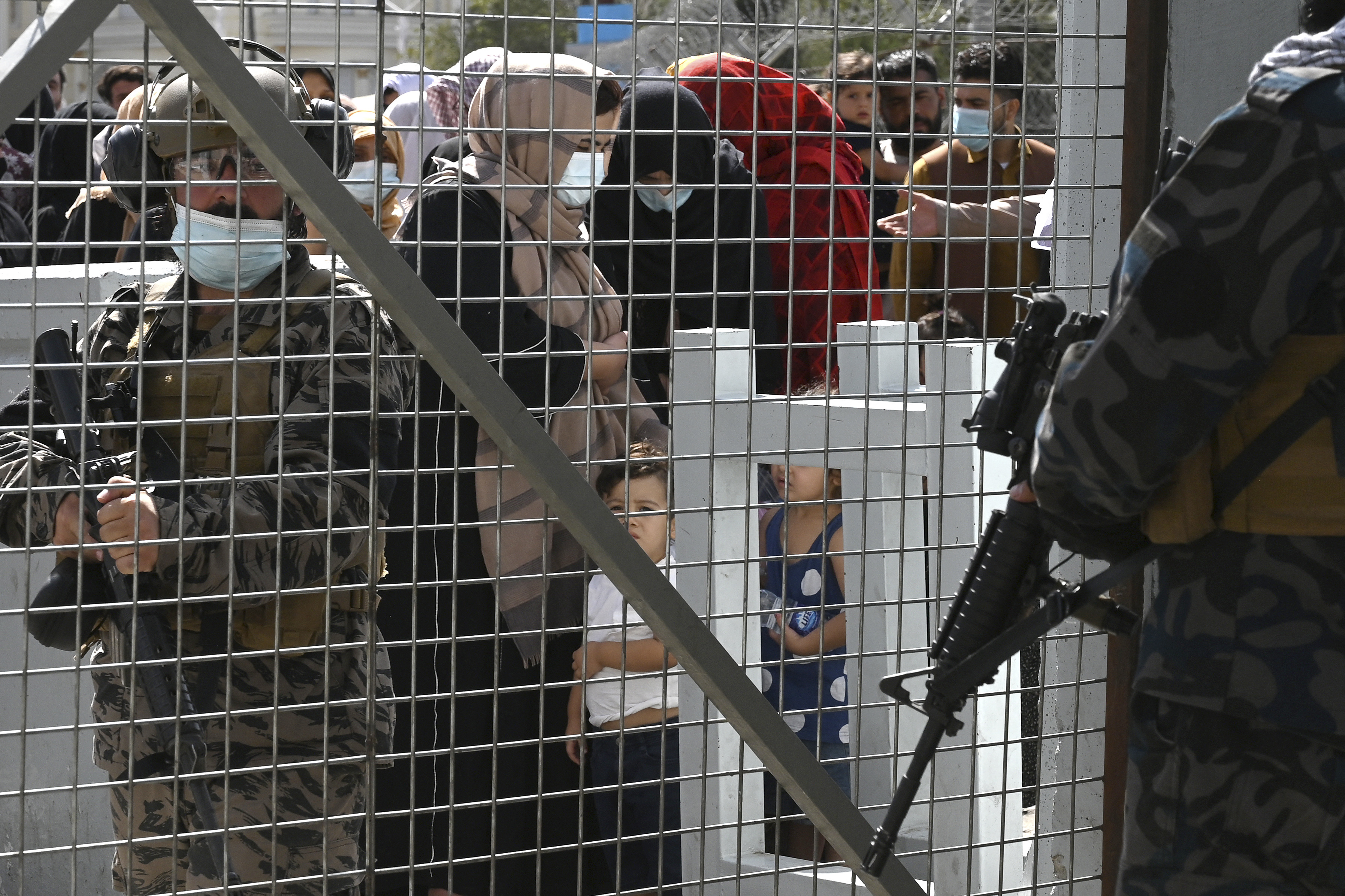 Taliban Badri fighters stand guard as Afghans, hoping to leave Afghanistan, wait at the main entrance gate of Kabul airport in Kabul on August 28, 2021 [Wakil Kohsar/AFP]