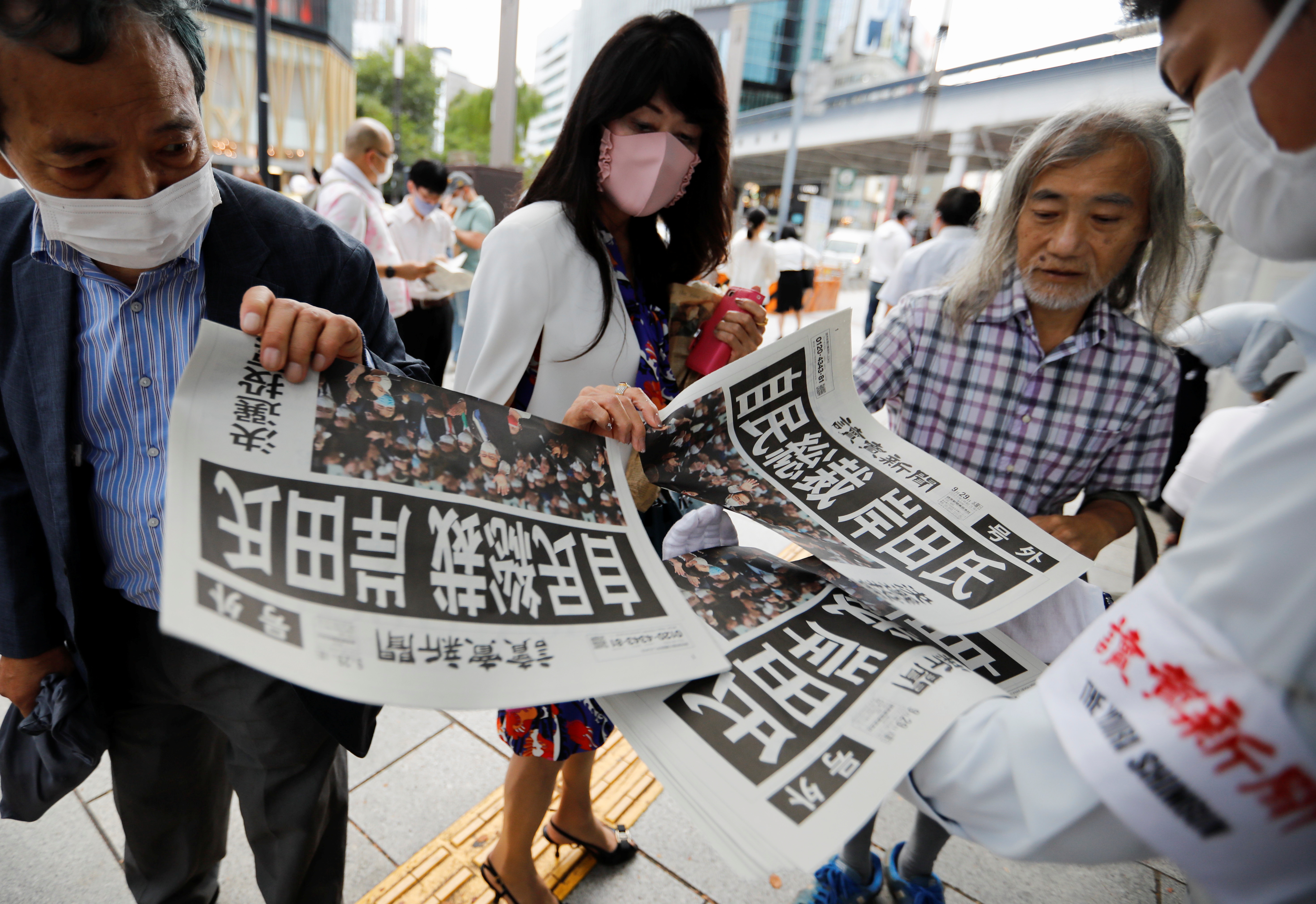 People rush to get extra editions of a newspaper reporting the victory of former Japanese Foreign Minister Fumio Kishida in the ruling party election. It is not clear whether they will prove as enthusiastic when it comes to the election [Issei Kato/Reuters]