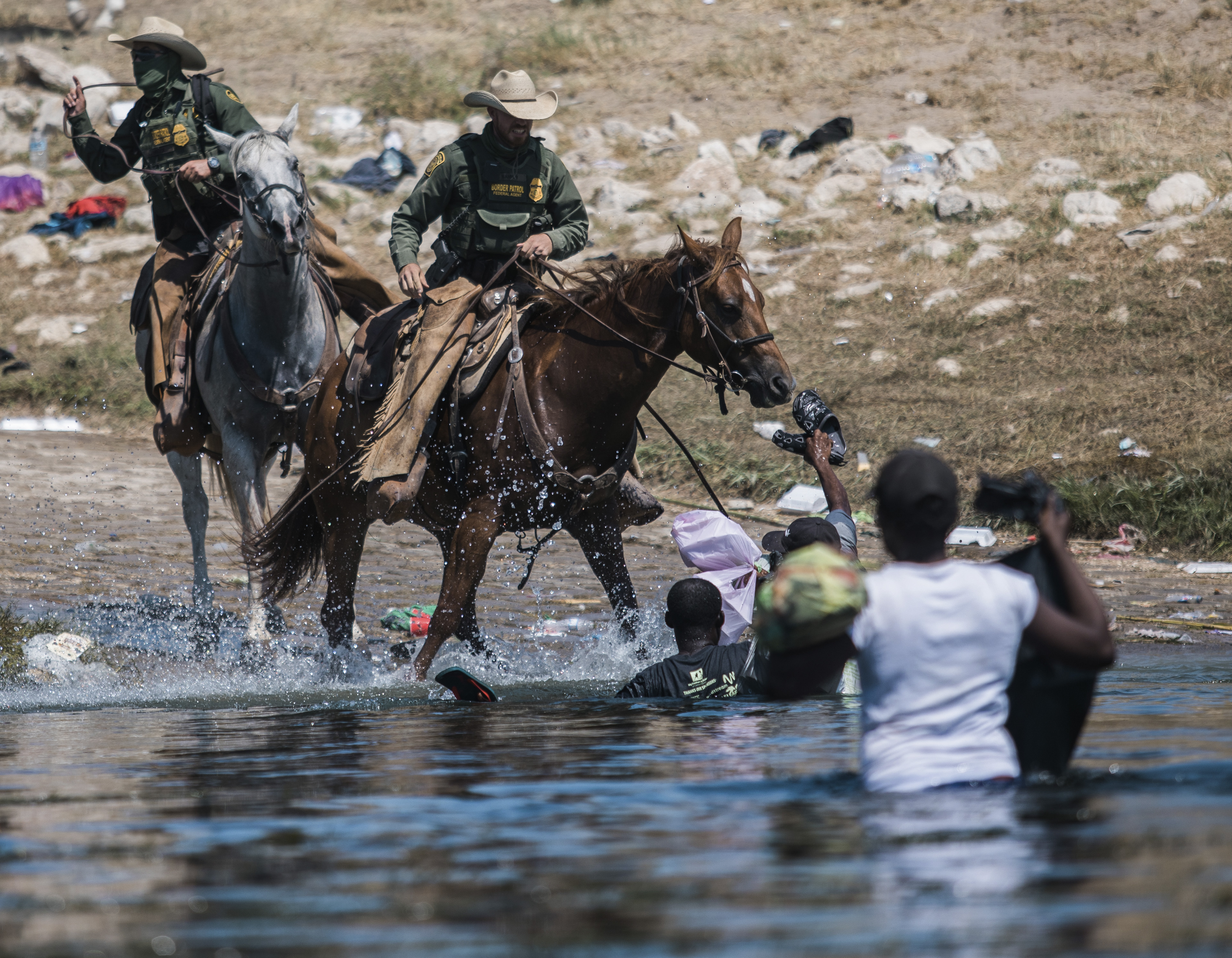 US Customs and Border Protection mounted officers try to push back asylum seekers, as they cross the Rio Grande from Ciudad Acuña, Mexico, into Del Rio, Texas on September 19, 2021 [AP/Felix Marquez]