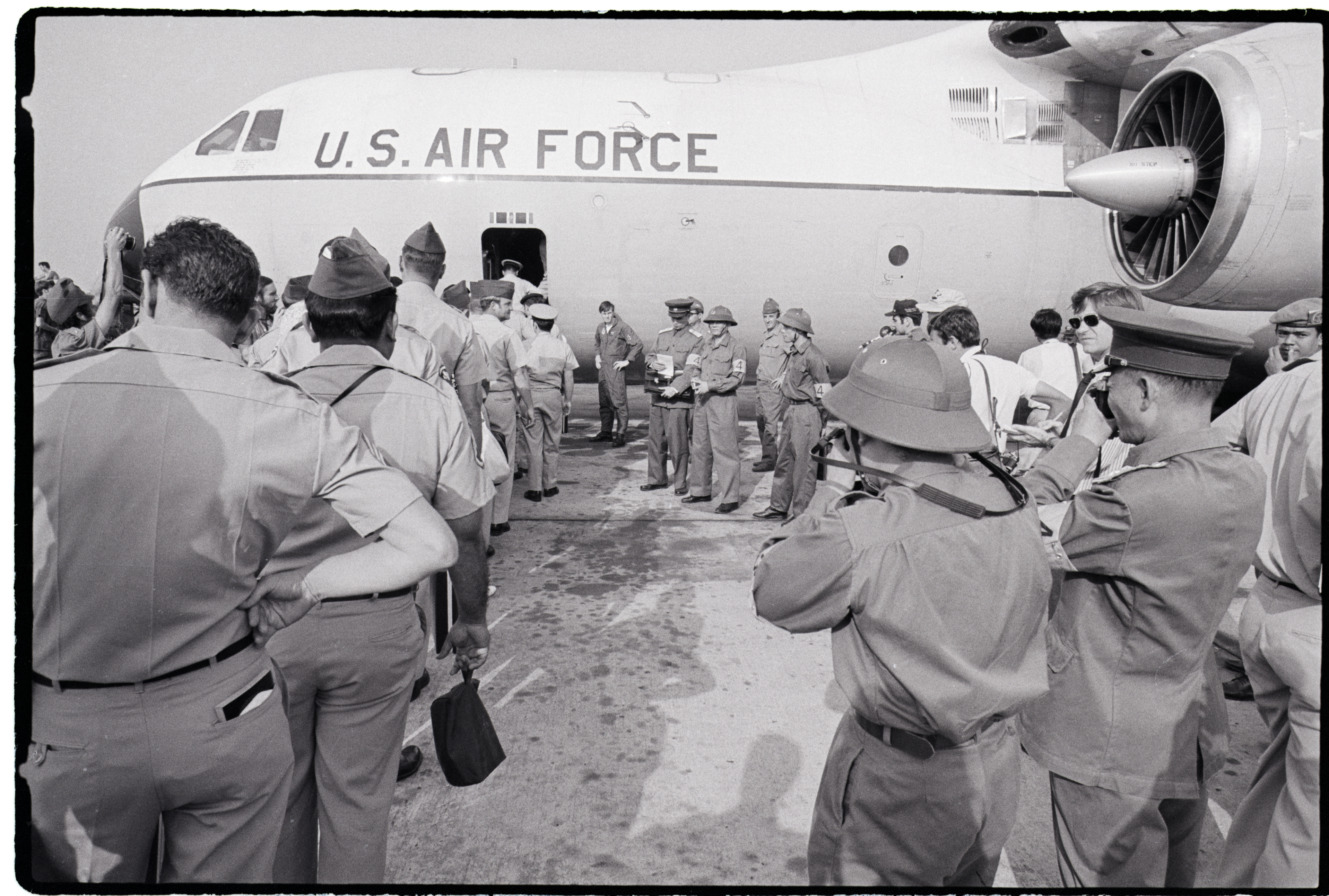 American troops board a US Air Force jet during a test withdrawal at Tan Son Nhut Air Base while Vietcong and North Vietnamese officers take photographs near Saigon, Vietnam