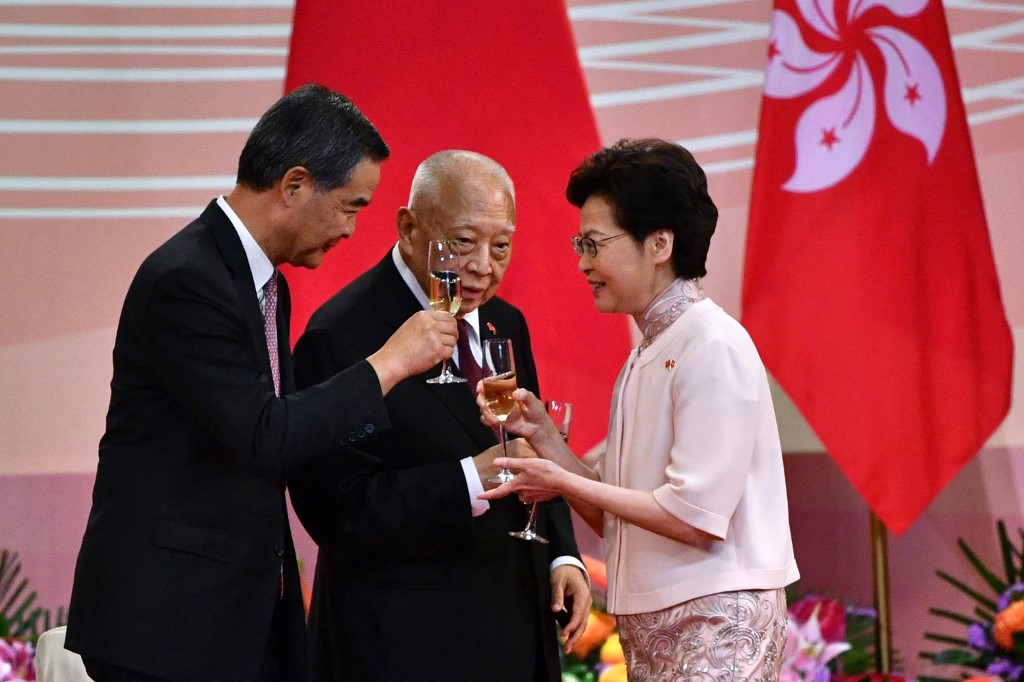 Former Hong Kong chief executives CY Leung, left, and Tung Chee-hwa, centre, toast with current leader Carrie Lam during the 23rd anniversary of Hong Kong's handover from Britain to China last year [File: Anthony Wallace/AFP]