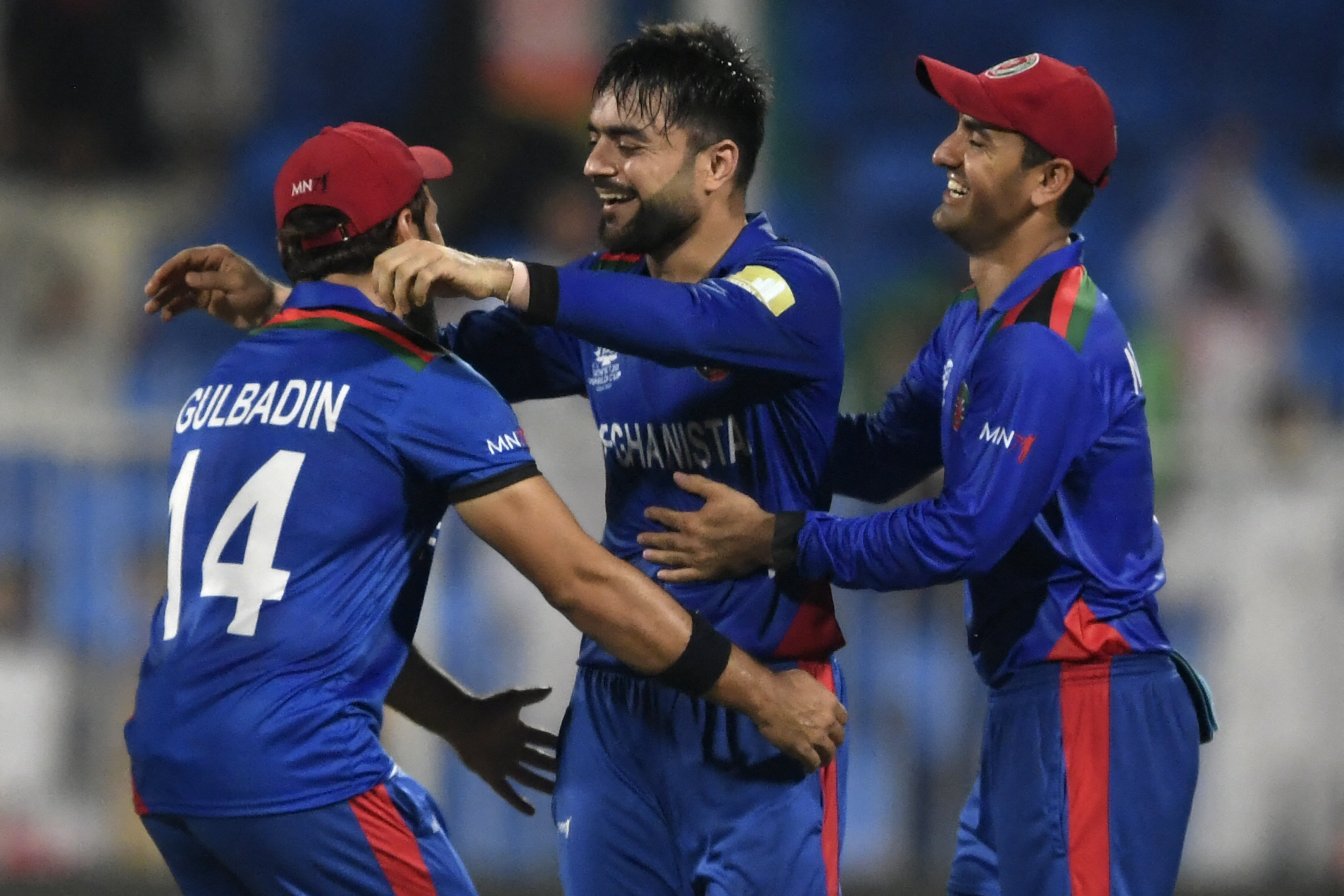 Afghanistan's Rashid Khan (C) celebrates with teammates after taking the wicket of Scotland's Brad Wheal (not pictured) during the ICC's Twenty20 World Cup cricket match between Afghanistan and Scotland at the Sharjah Cricket Stadium in Sharjah on October 25, 2021 [Aamir Qureshi/AFP]