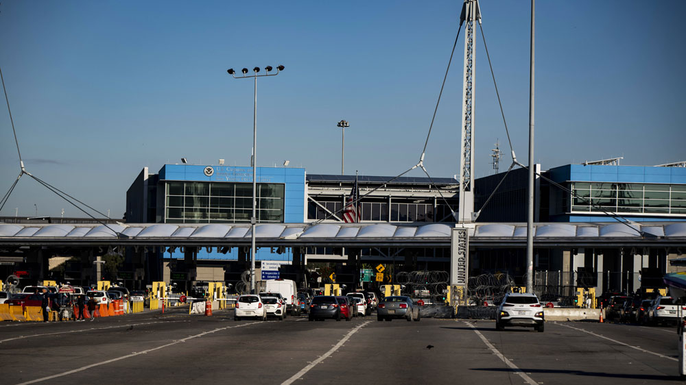 Travellers wait to cross into the United States at the San Ysidro Port of Entry border crossing in Tijuana, Baja California, Mexico, 21 March 2020.