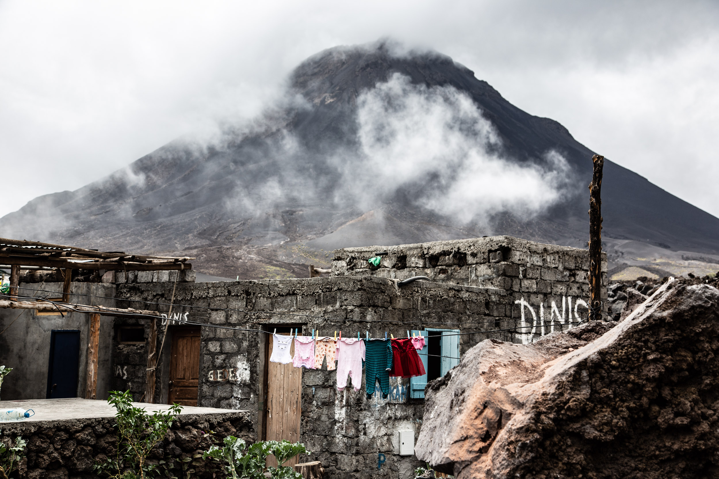 Children’s clothes hang to dry at the foot of the volcano. [Annika Hammerschlag/Al Jazeera]