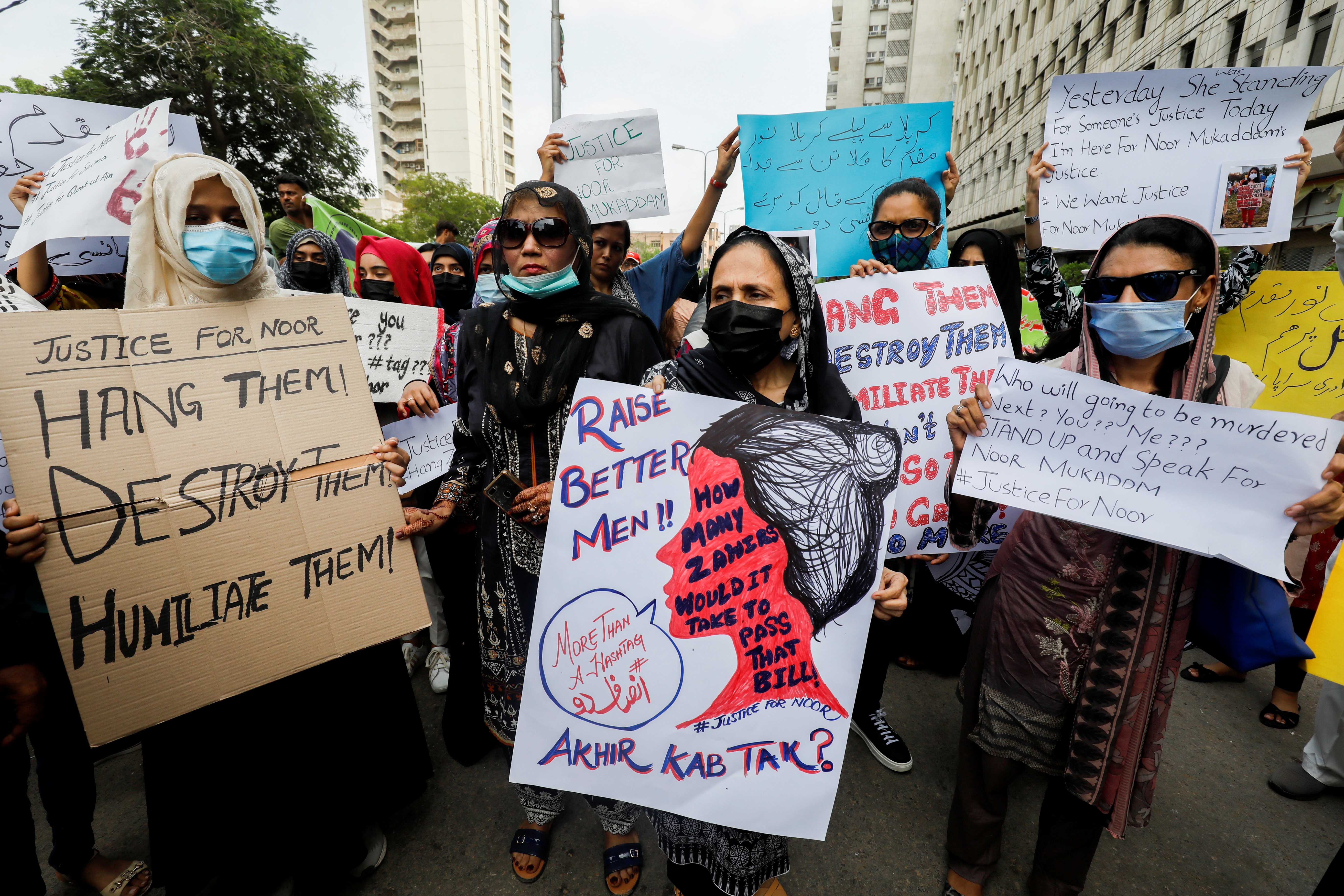 People carry signs against the killing of Noor Mukadam, 27, daughter of former Pakistani diplomat, and to condemn the violence against women and girls during a protest in Karachi, Pakistan July 25, 2021 [Akhtar Soomro/Reuters]