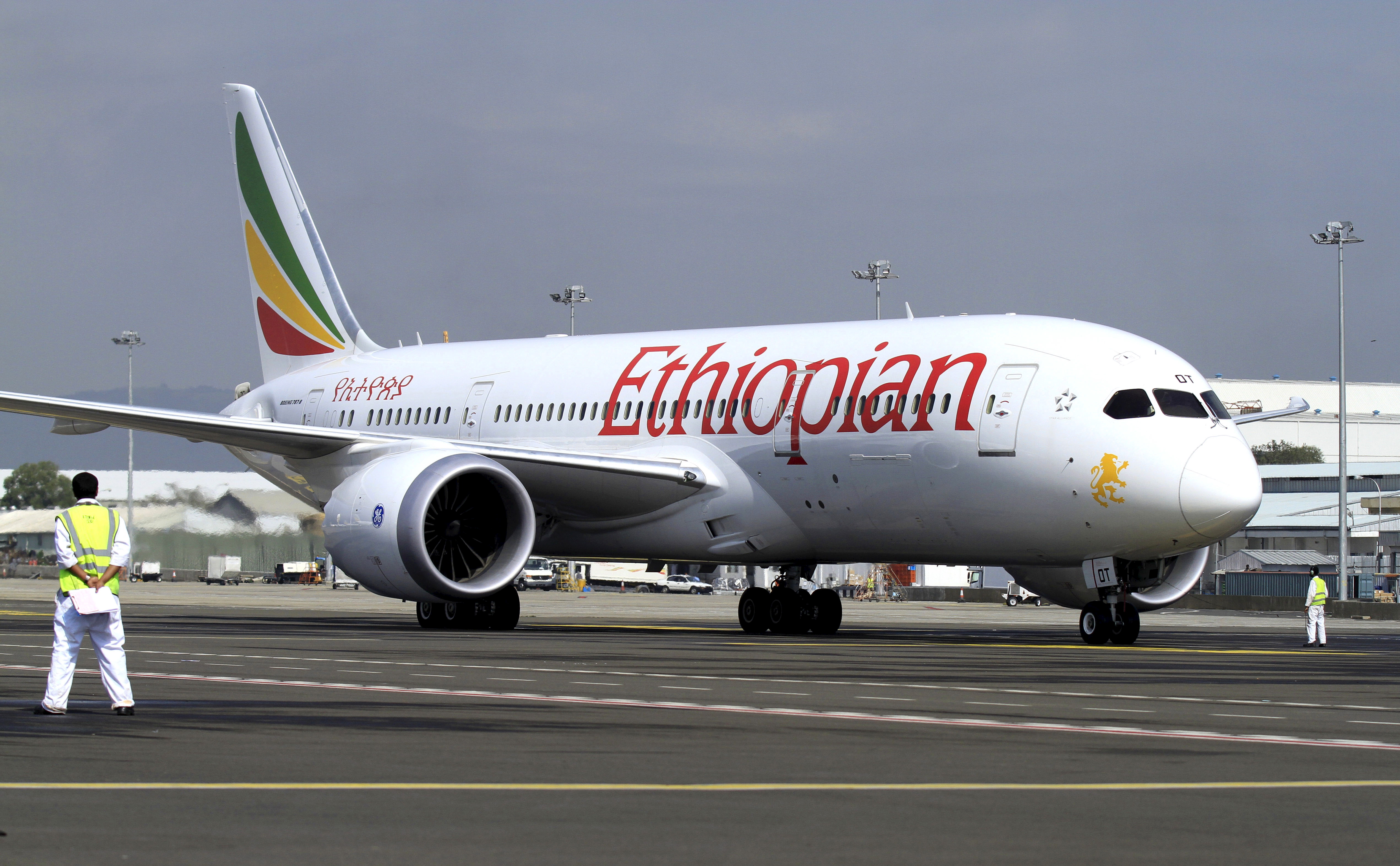 A member of the ground crew directs an Ethiopian Airlines Boeing 787-8 Dreamliner plane