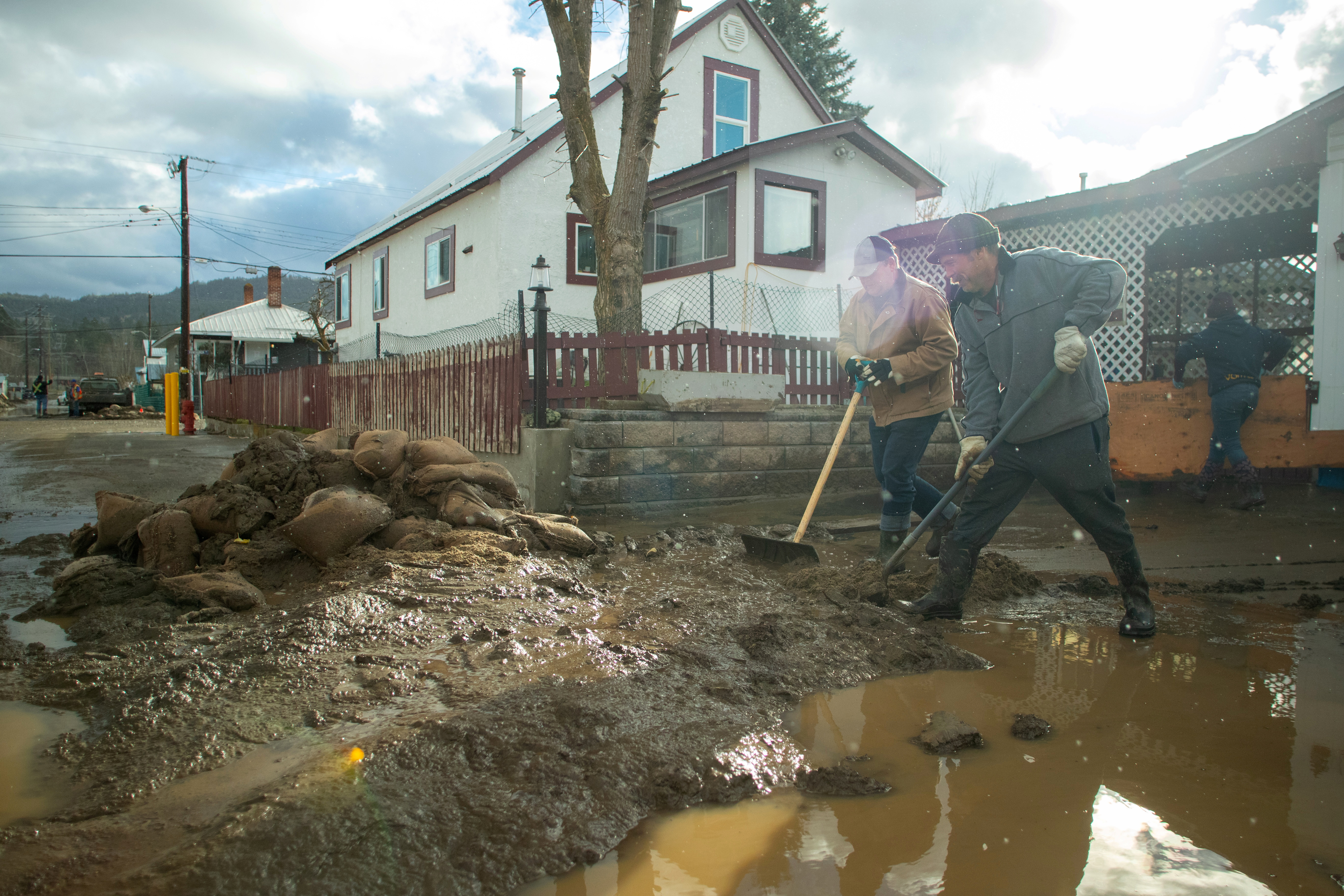 Residents clear thick mud outside a house a day after severe rain flooded the southern interior town of Princeton, British Columbia, Canada November 16, 2021. REUTERS/Artur Gajda