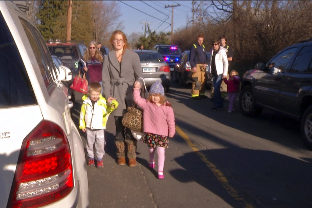 After being reunited with family outside Sandy Hook Elementary School in Newtown, Connecticut, people leave the area.