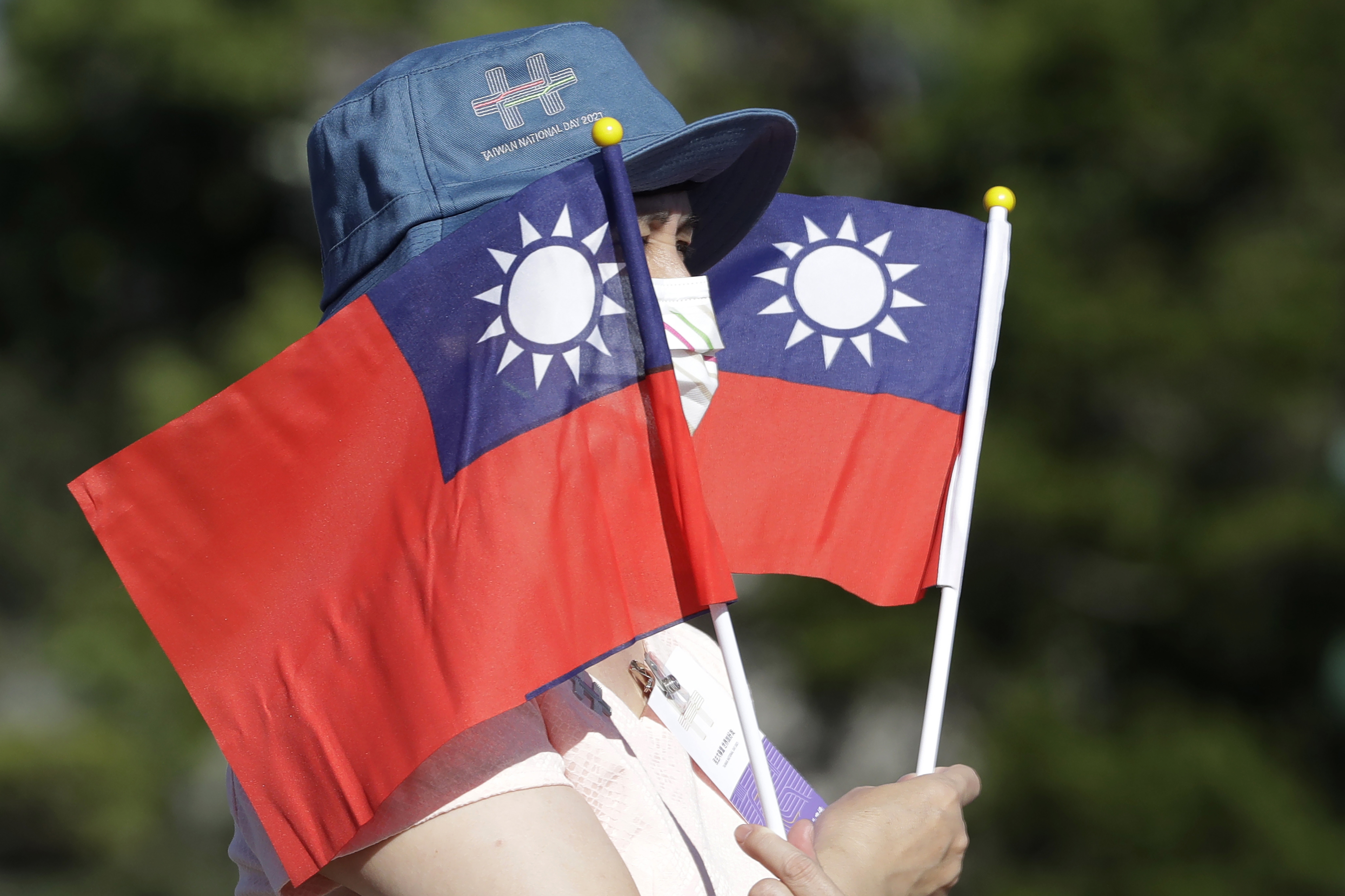A woman holds up Taiwan national flags
