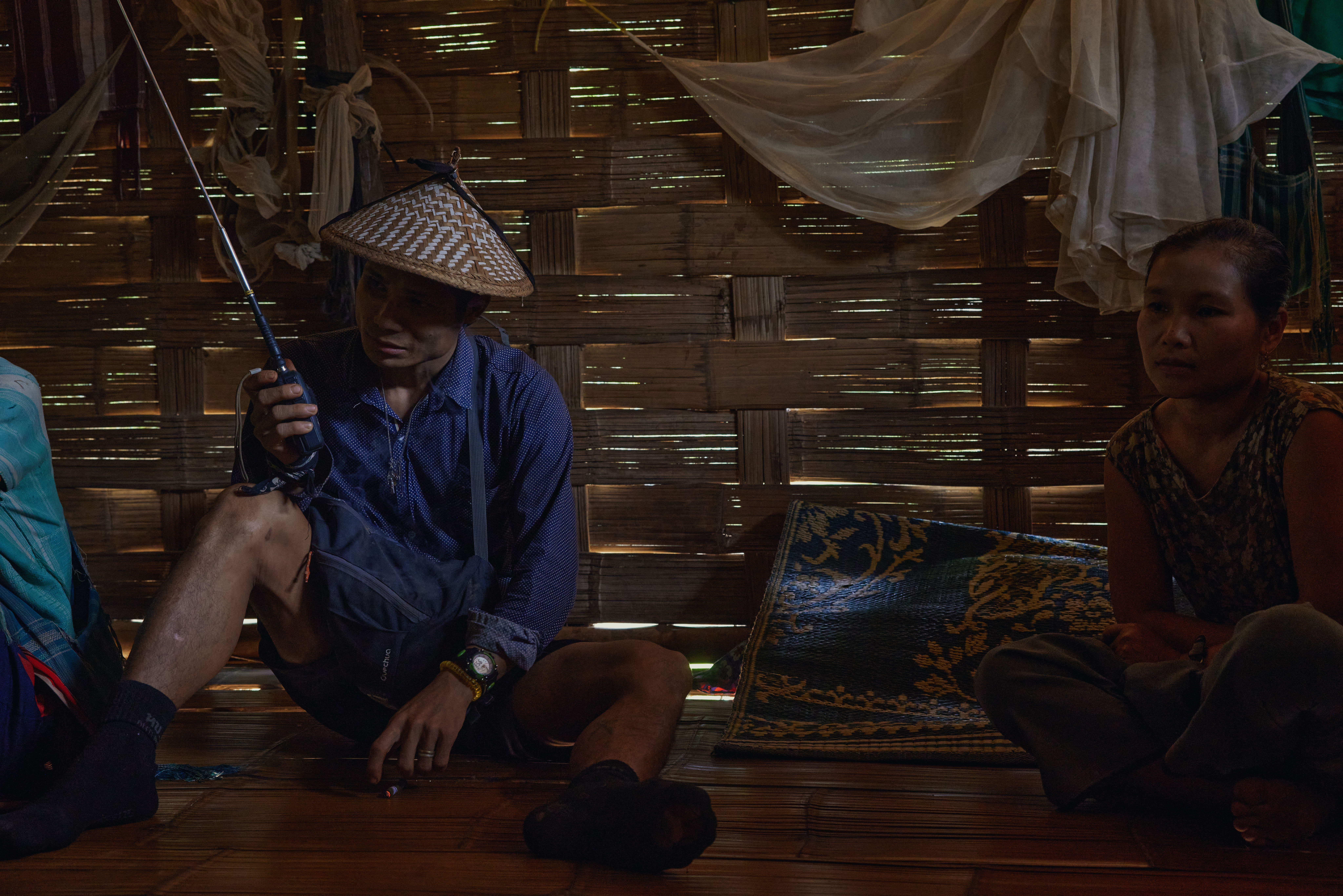 With no phone reception in the remote jungle village, a resident of Nyah Beh Ki uses a walkie-talkie to keep tabs on the local security situation. Sandwiched between two Tatmadaw outposts, the village has suffered repeated harassment from the enemy soldiers. As one villager testified "...they started shelling our villages so we had to hide in a bunker… Many of the shells hit right around my home so I also had to run... Then they proceeded to ransack and destroy any home which had been abandoned.” [Al Jazeera] - DO NOT USE