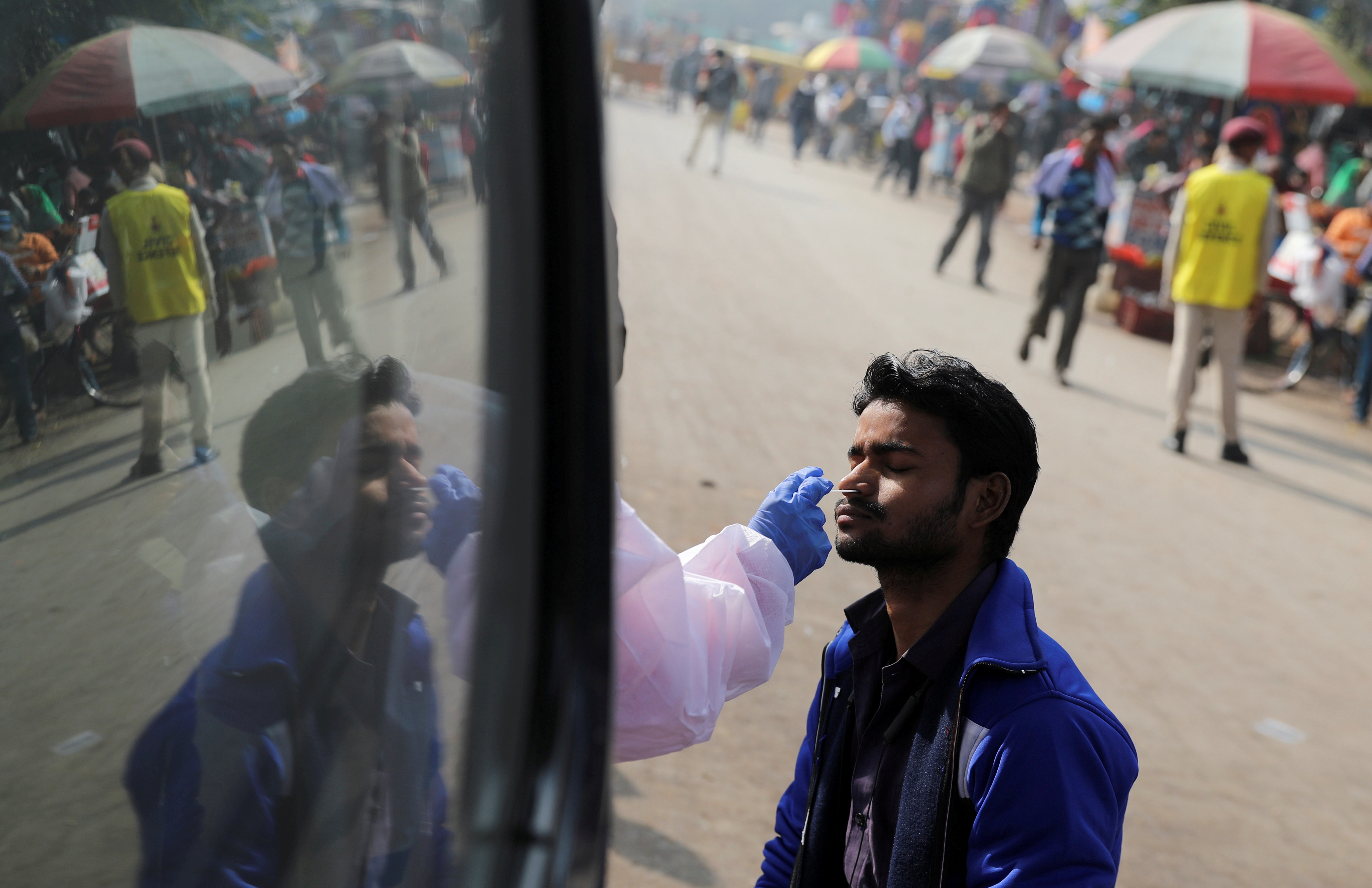 A healthcare worker collects a coronavirus disease test swab in India