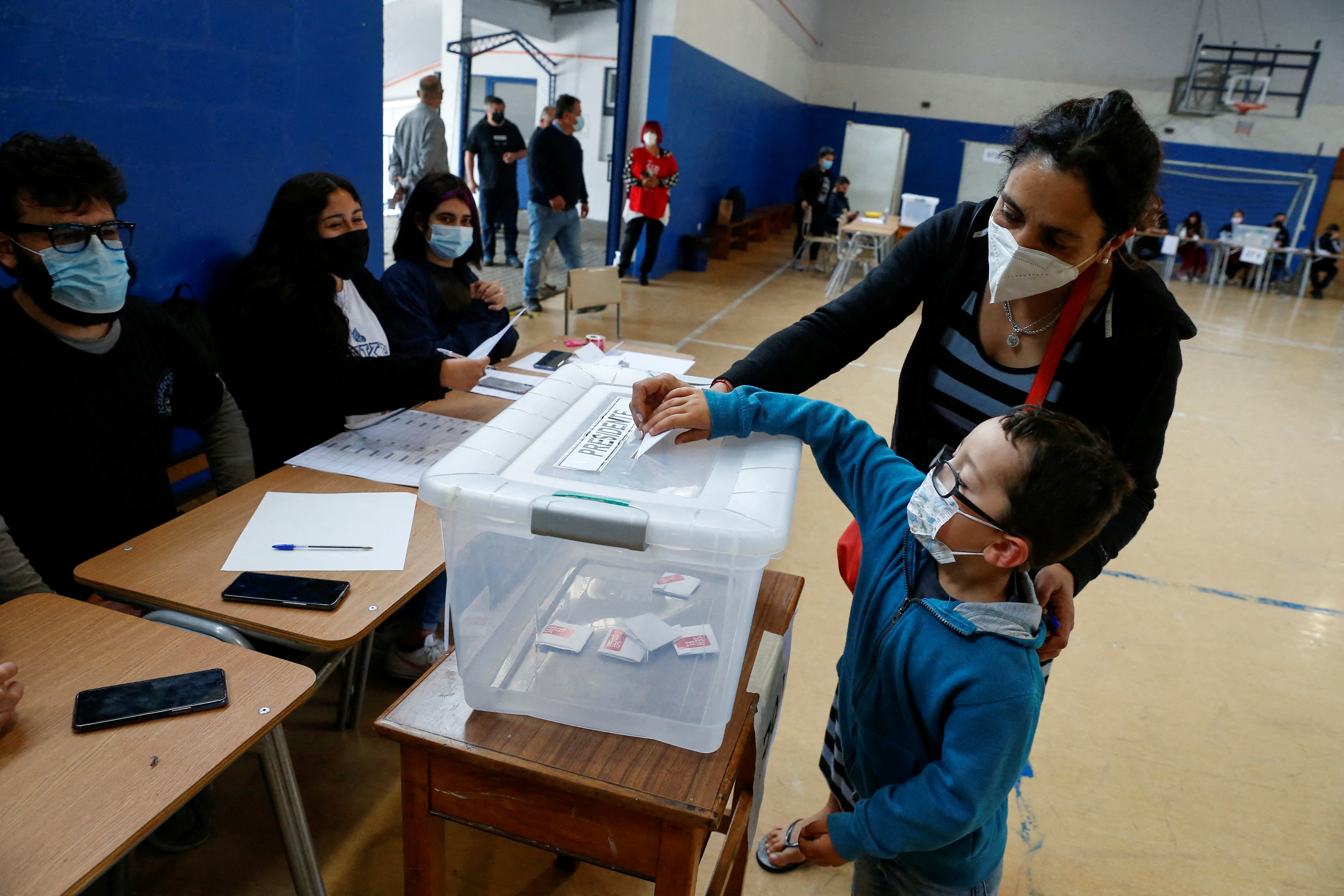 A child casts a ballot on behalf of his mother during the presidential election at a polling station in Valparaiso, Chile [Rodrigo Garrido/Reuters]