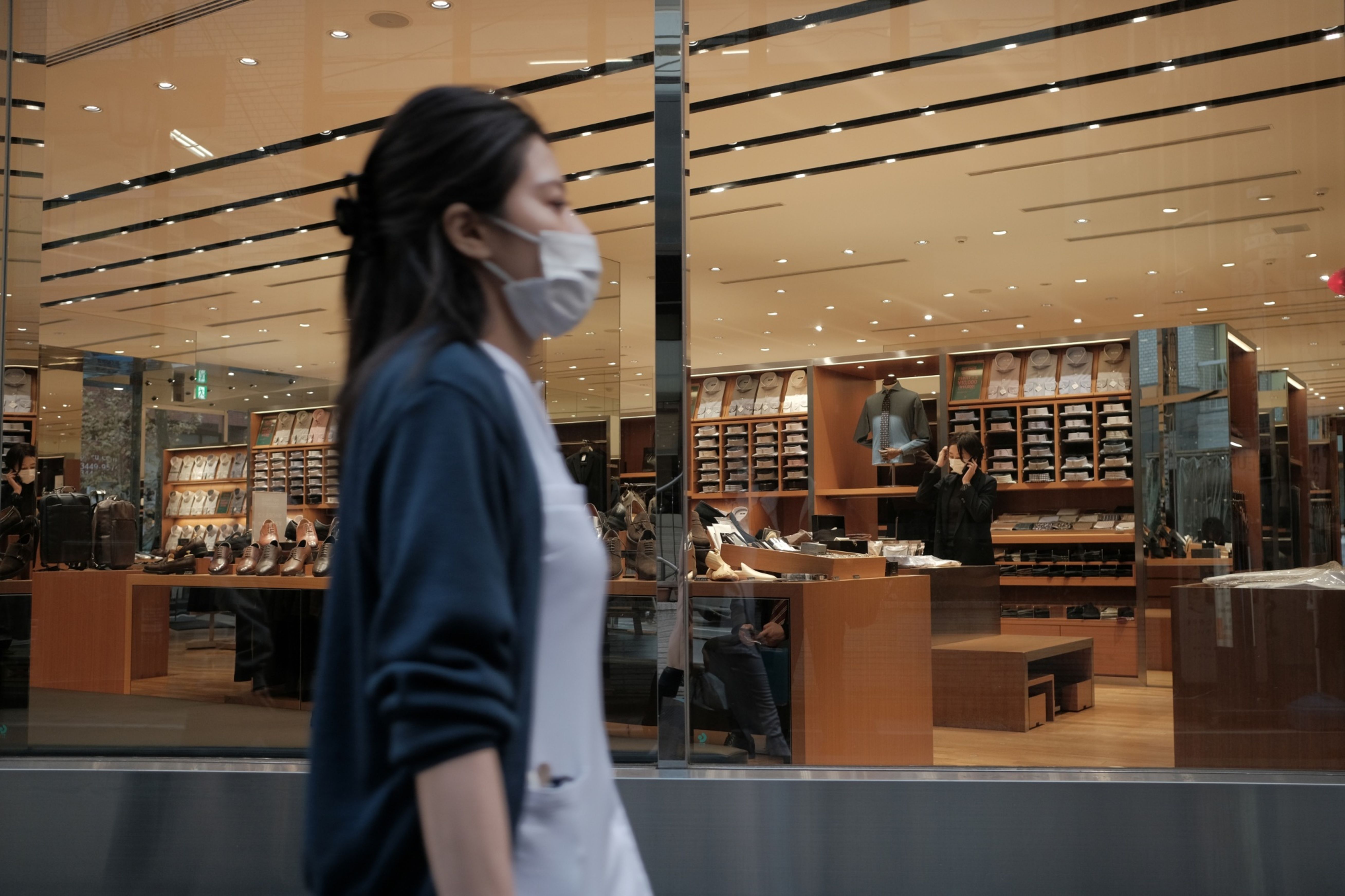 A pedestrian walks past a department store in Tokyo, Japan
