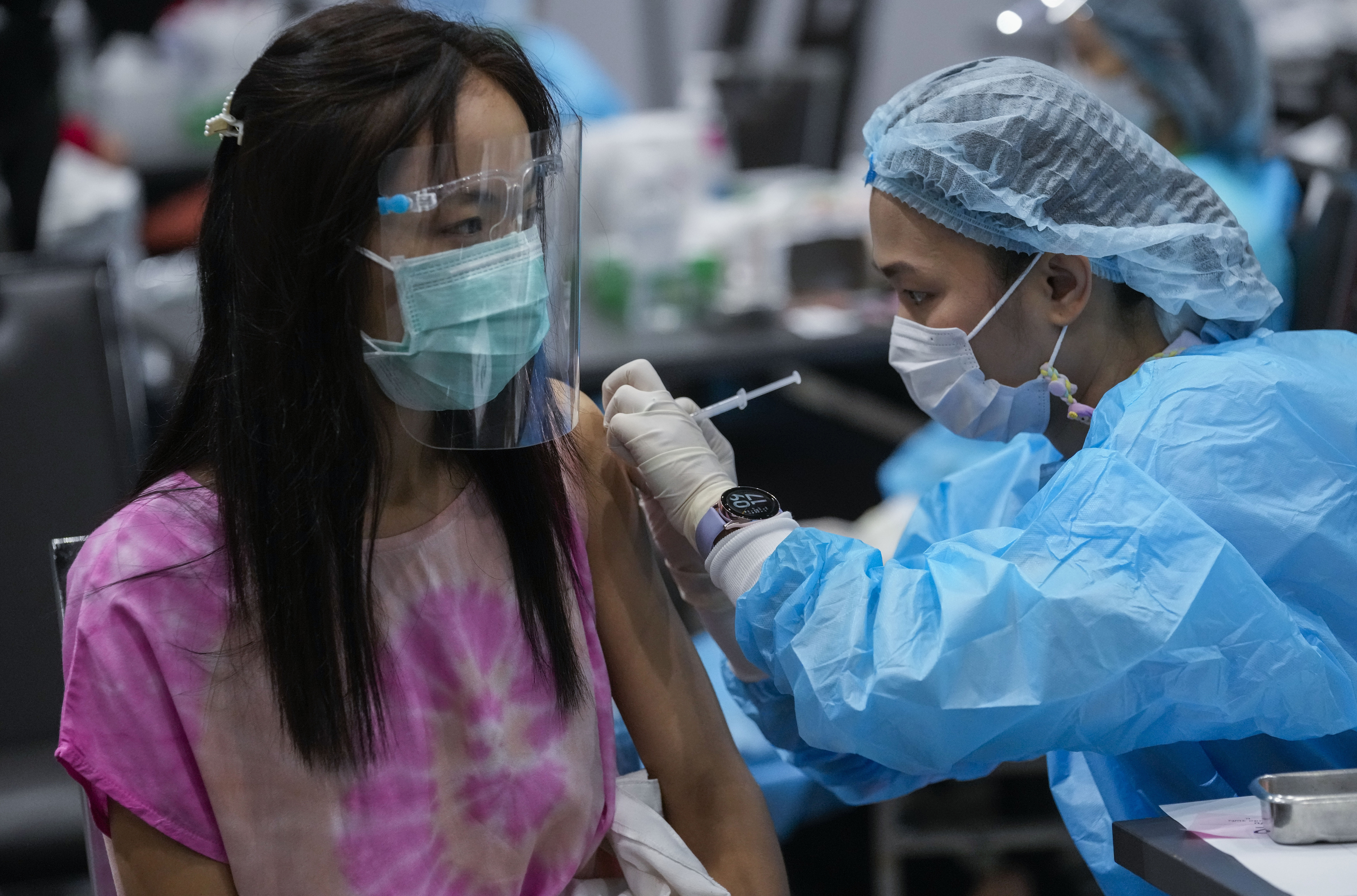 A woman receives vaccine from a health worker in Thailand