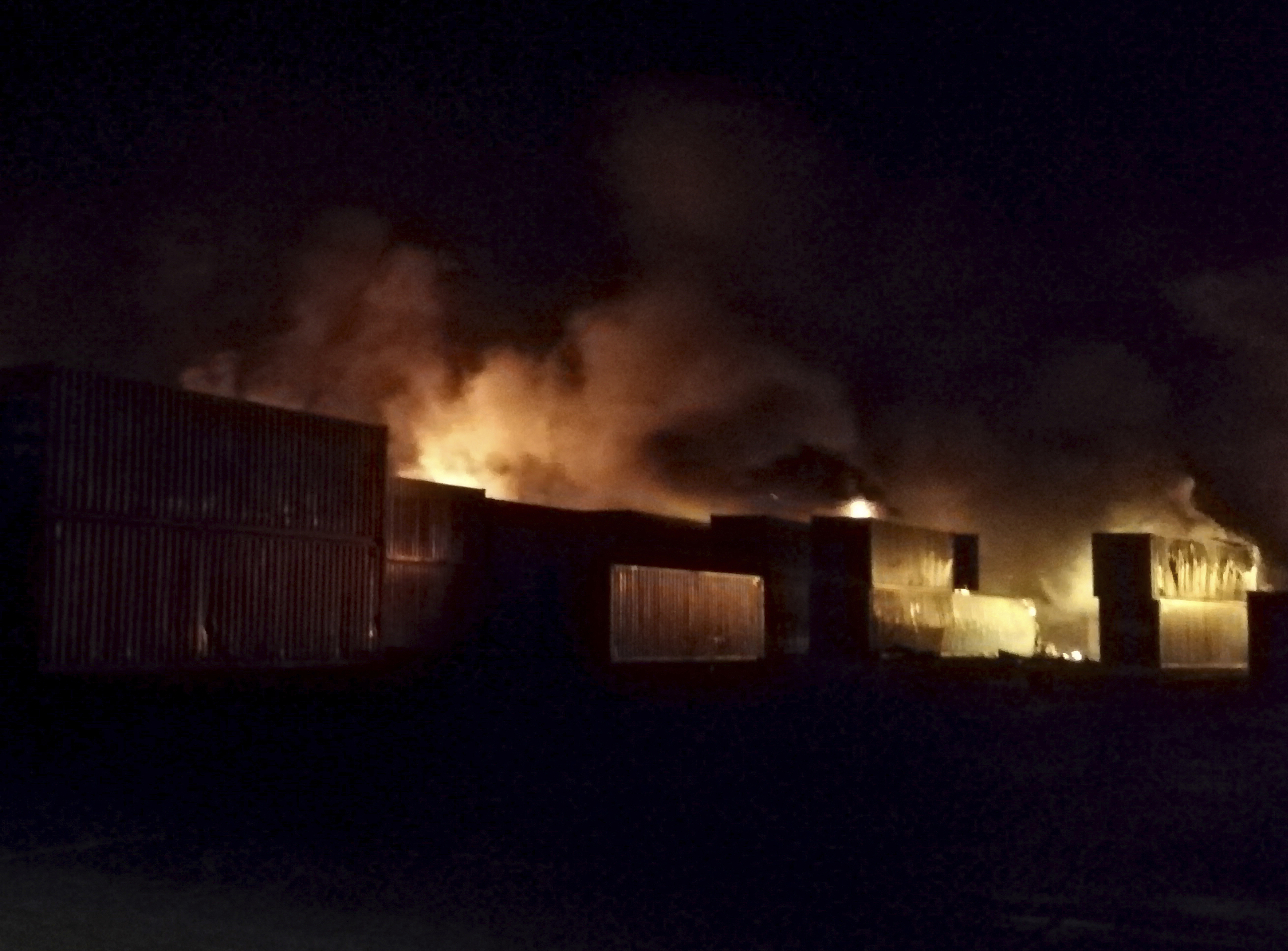 Flames rise from containers at the scene of missiles attack, at Latakia, Syria