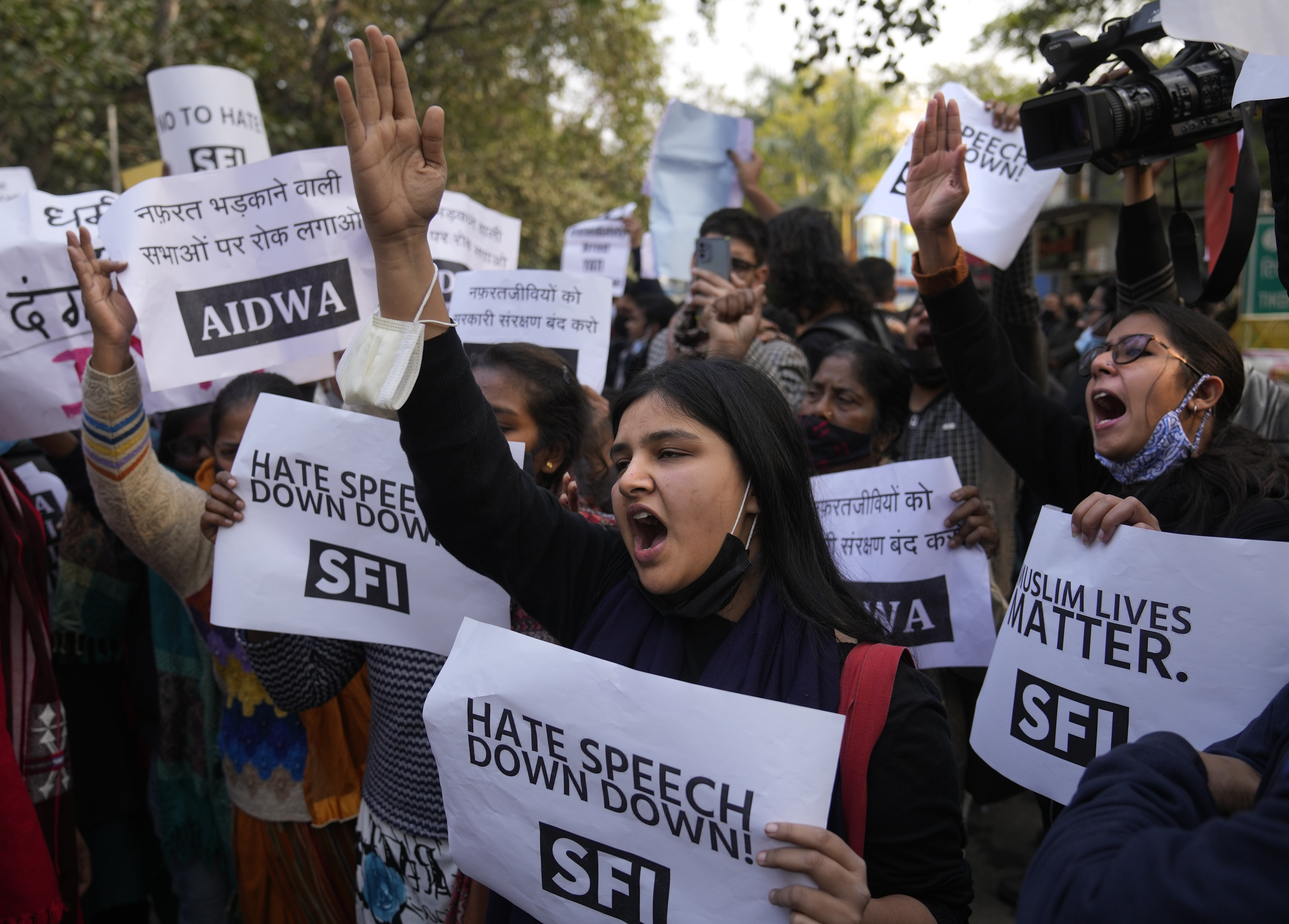 Female activists shout slogans against hate speech while holding signs that read "down with hate speech" and "Muslim lives matter" in New Delhi