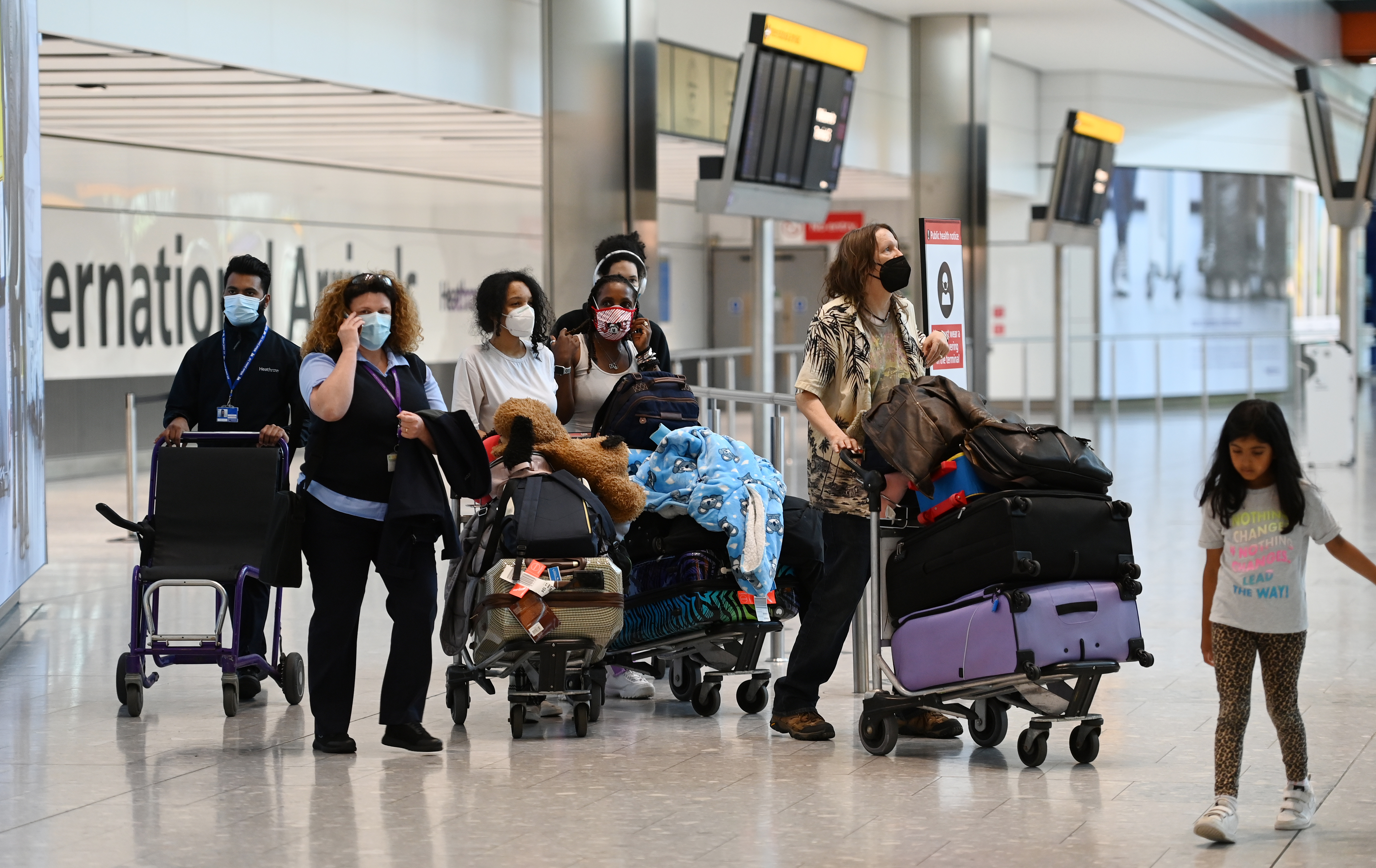 Travellers stand at Heathrow airport in London