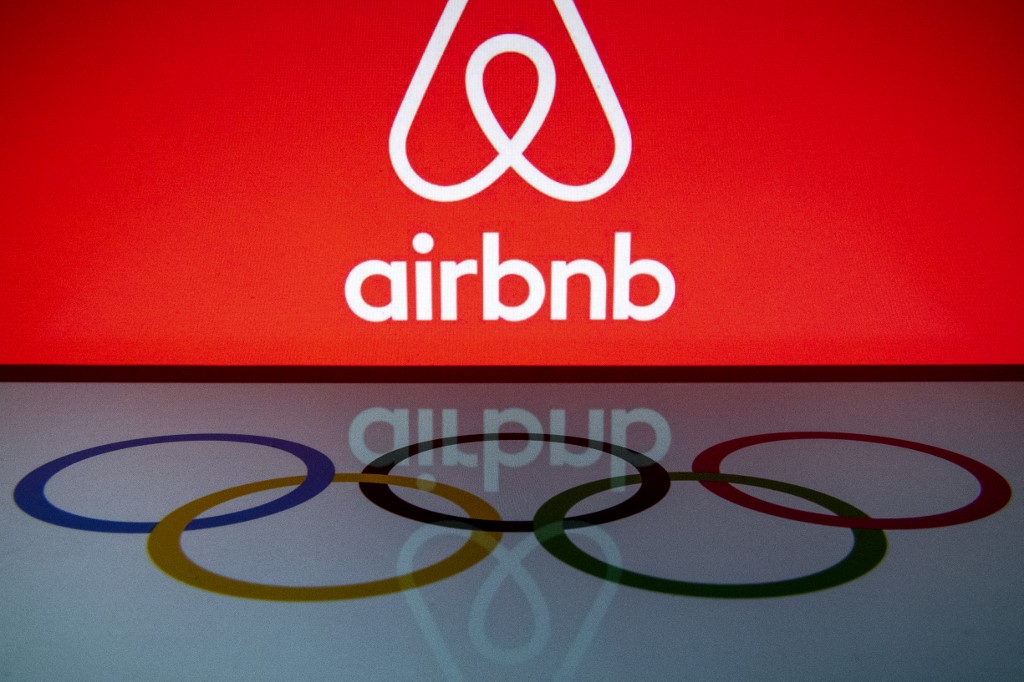 Airbnb logo in the upper half of the frame and Olympic rings logo in the lower half.