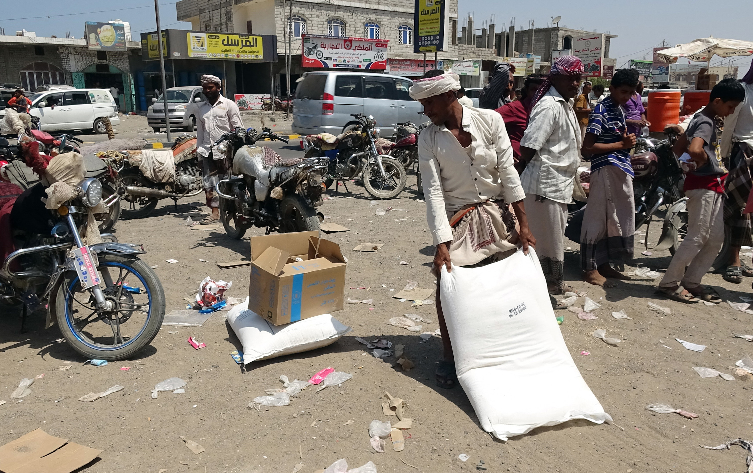 Displaced Yemenis receive humanitarian aid provided by the World Food Programme (WFP) in the Khokha district of Yemen's war-ravaged western province of Hodeida, on March 29, 2021. (Photo by Khaled Ziad / AFP)