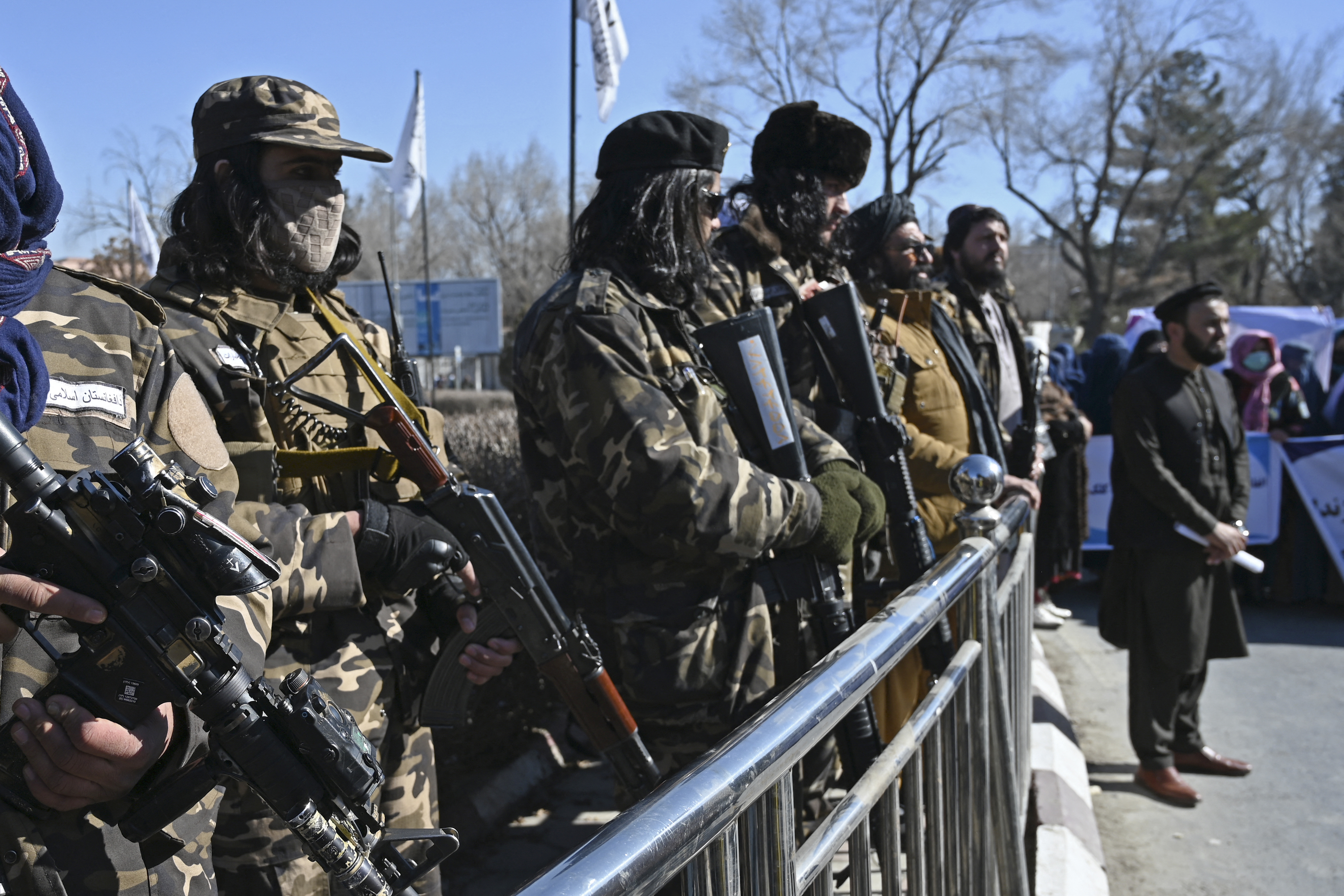 Taliban fighters stand guard during a women's protest