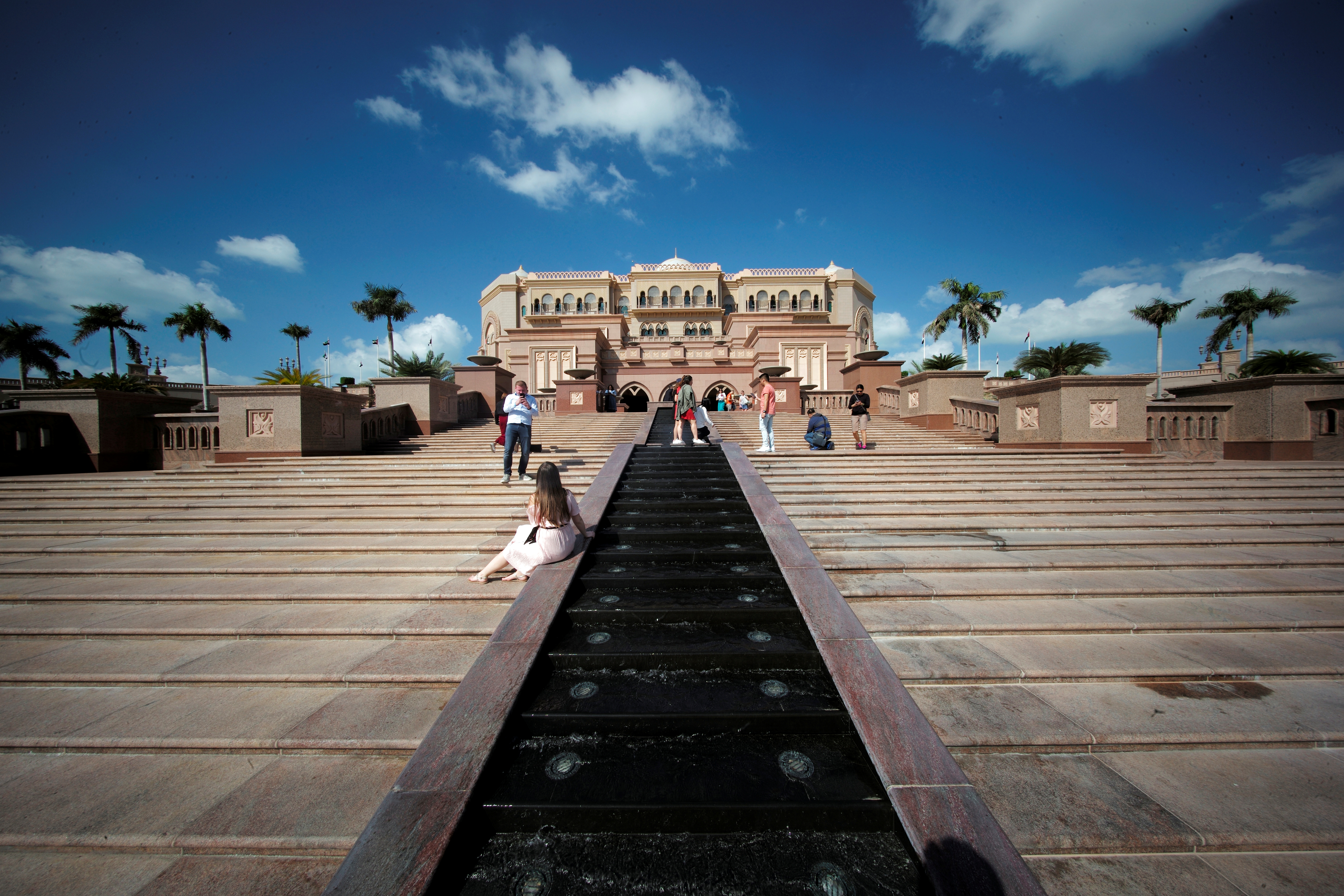 Tourists take photos at the entrance of the Emirates Palace Hotel in Abu Dhabi