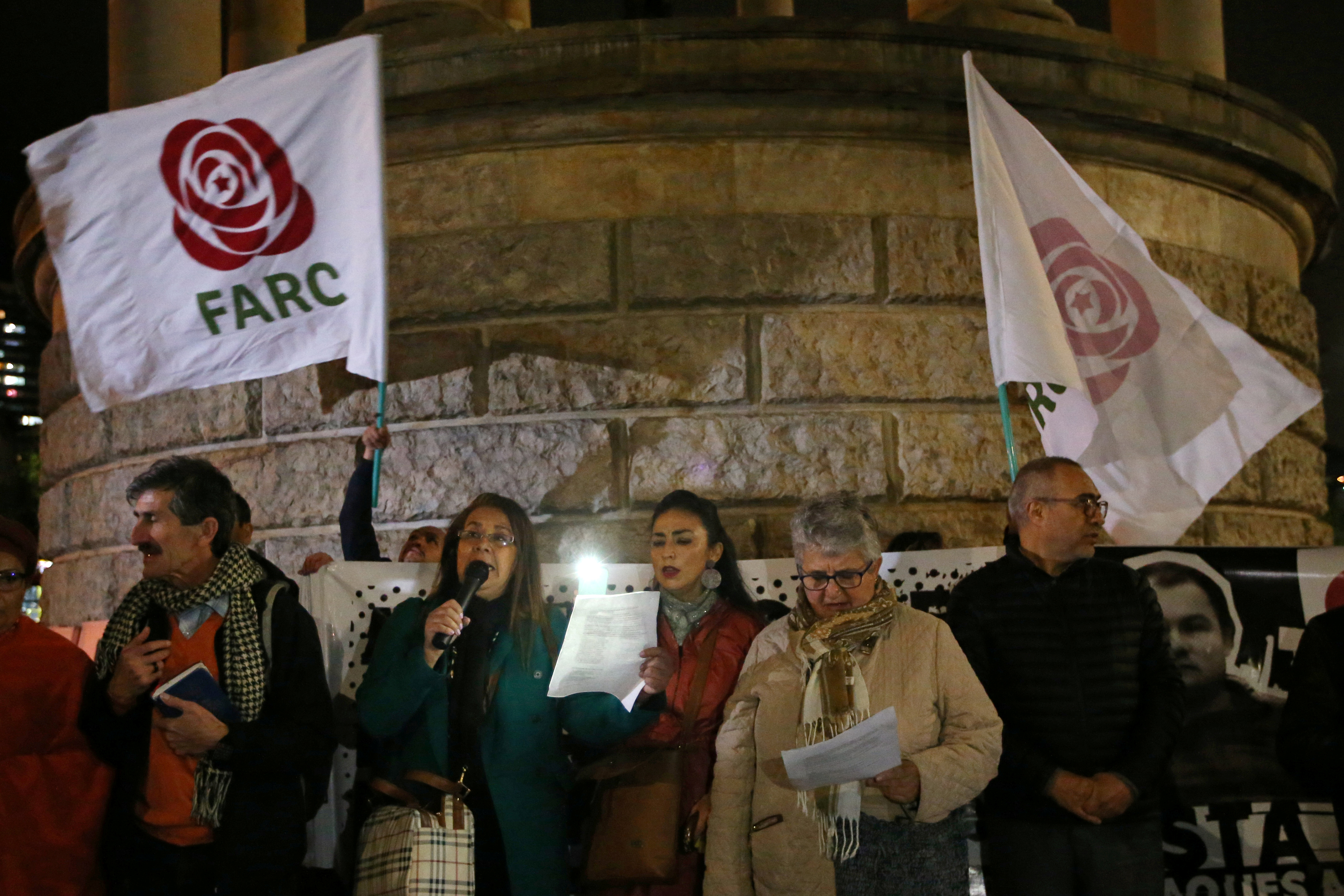FARC supporters attending a vigil hold flags aloft