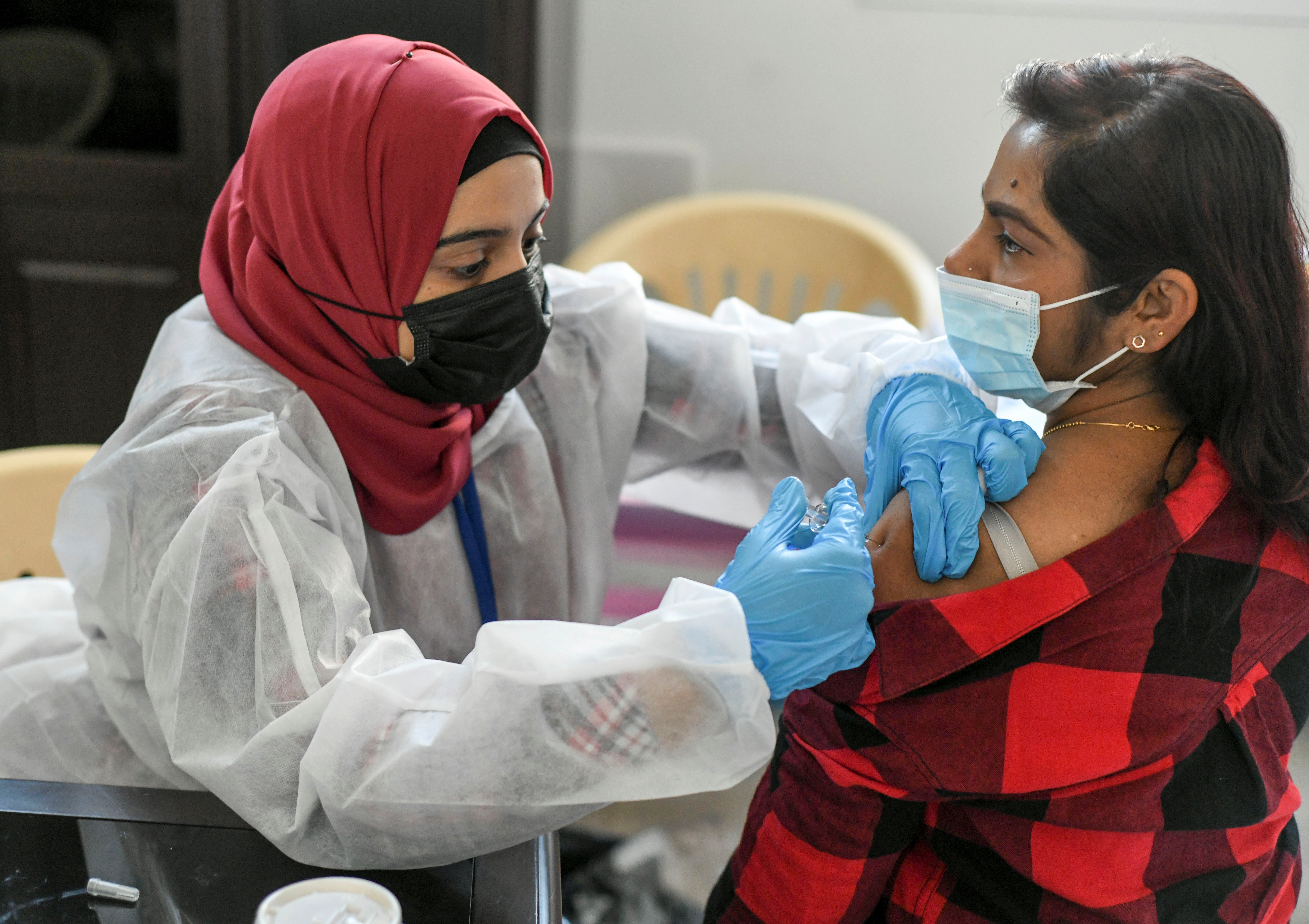 A woman receives a dose of a COVID-19 vaccine at St. Paul's Church in Abu Dhabi