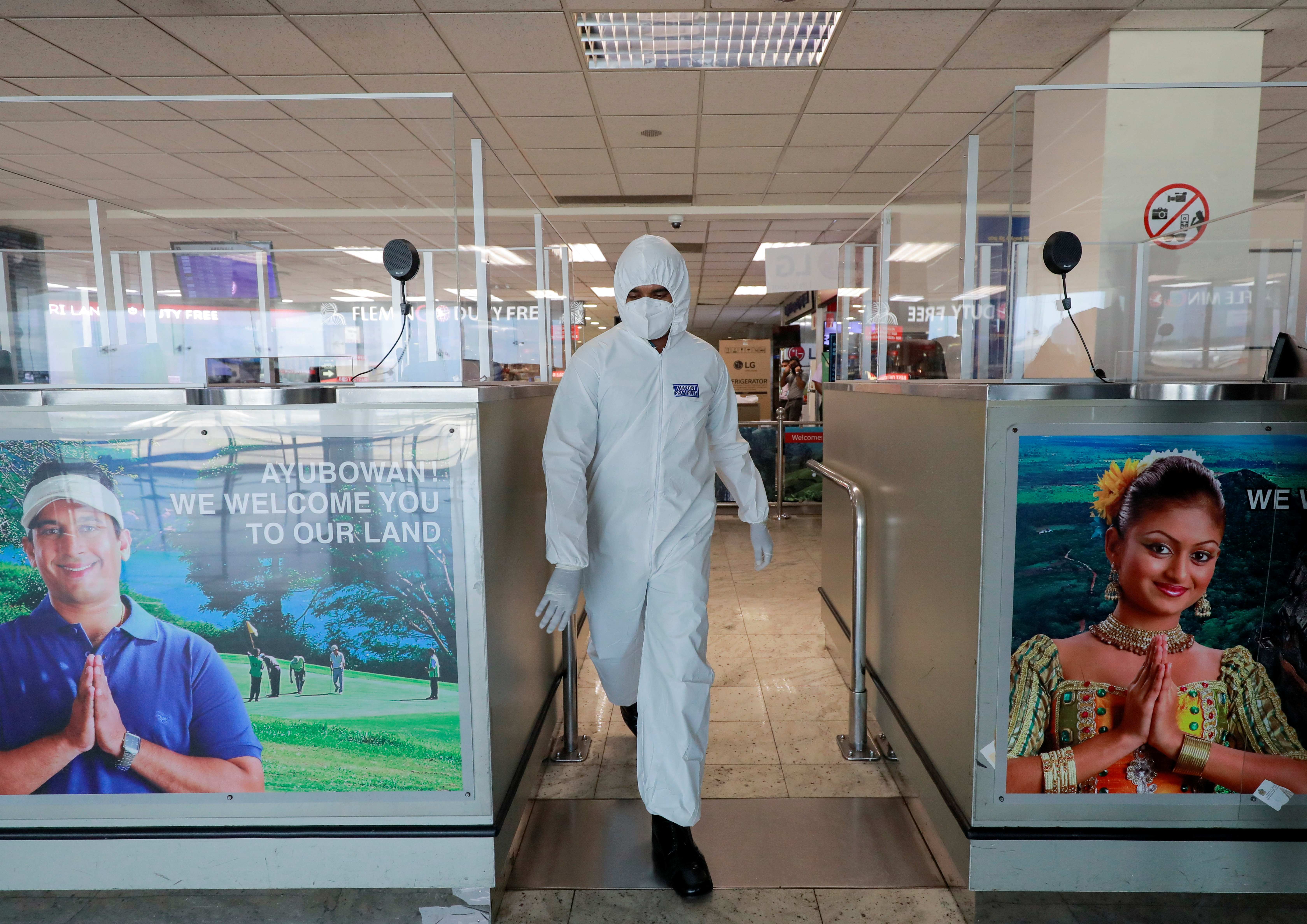 An officer wearing protective gear walks inside an airport in Sri Lanka