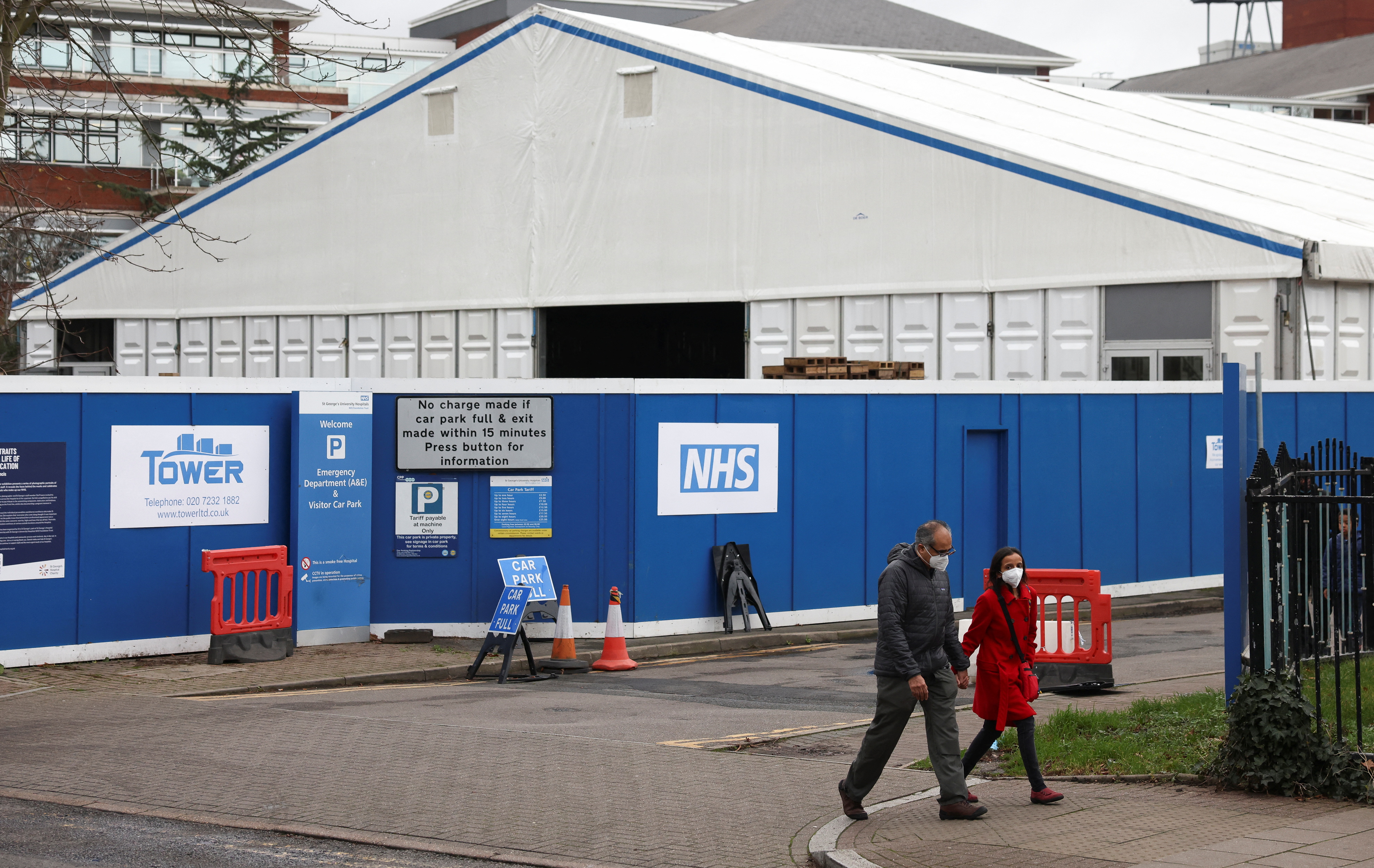 People walk past the site of a temporary field hospital in the grounds of St. George's Hospital