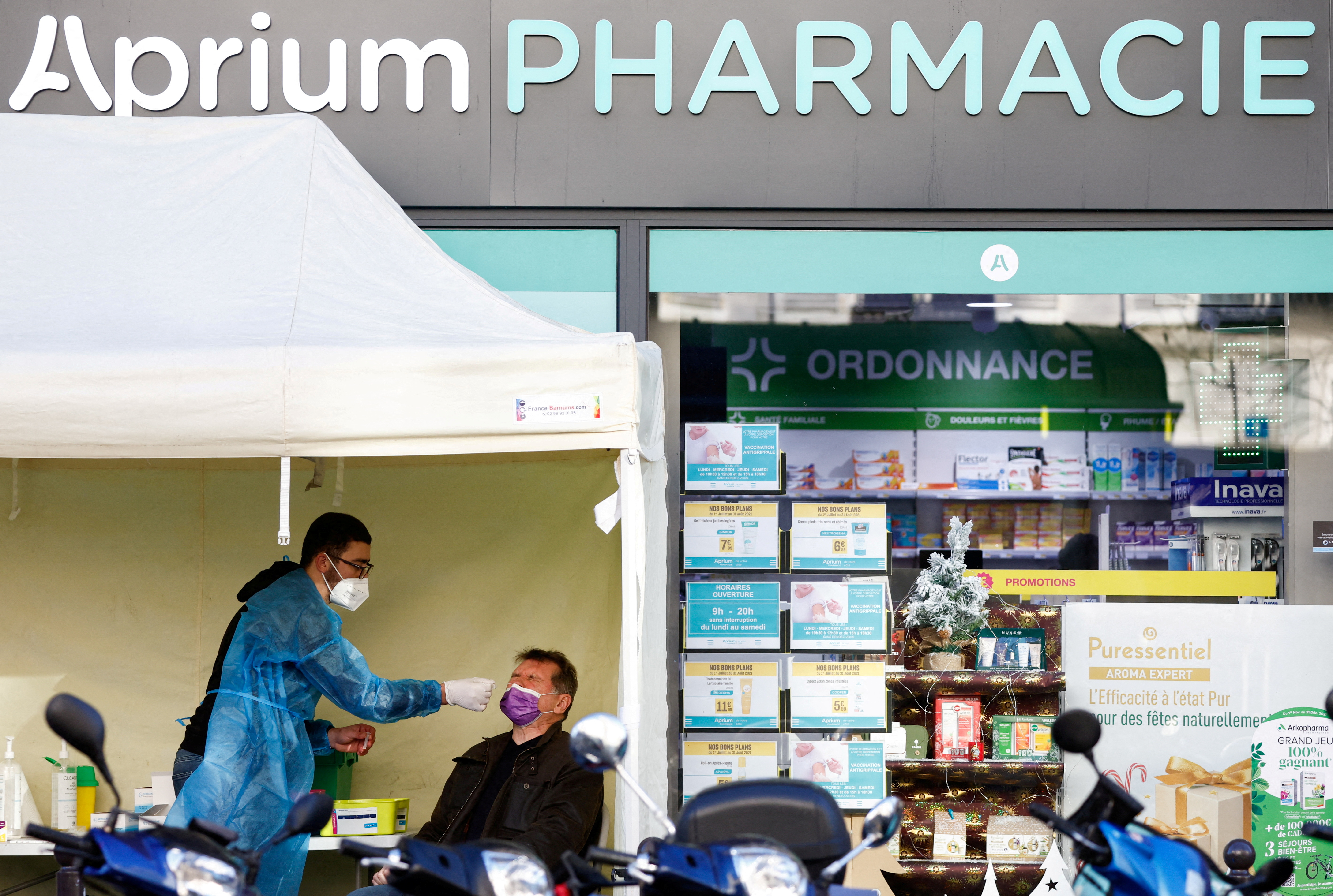 A medical worker administers a nasal swab to a man at a coronavirus disease (COVID-19) testing point in Paris, France, December 31, 2021. REUTERS/Christian Hartmann/File Photo
