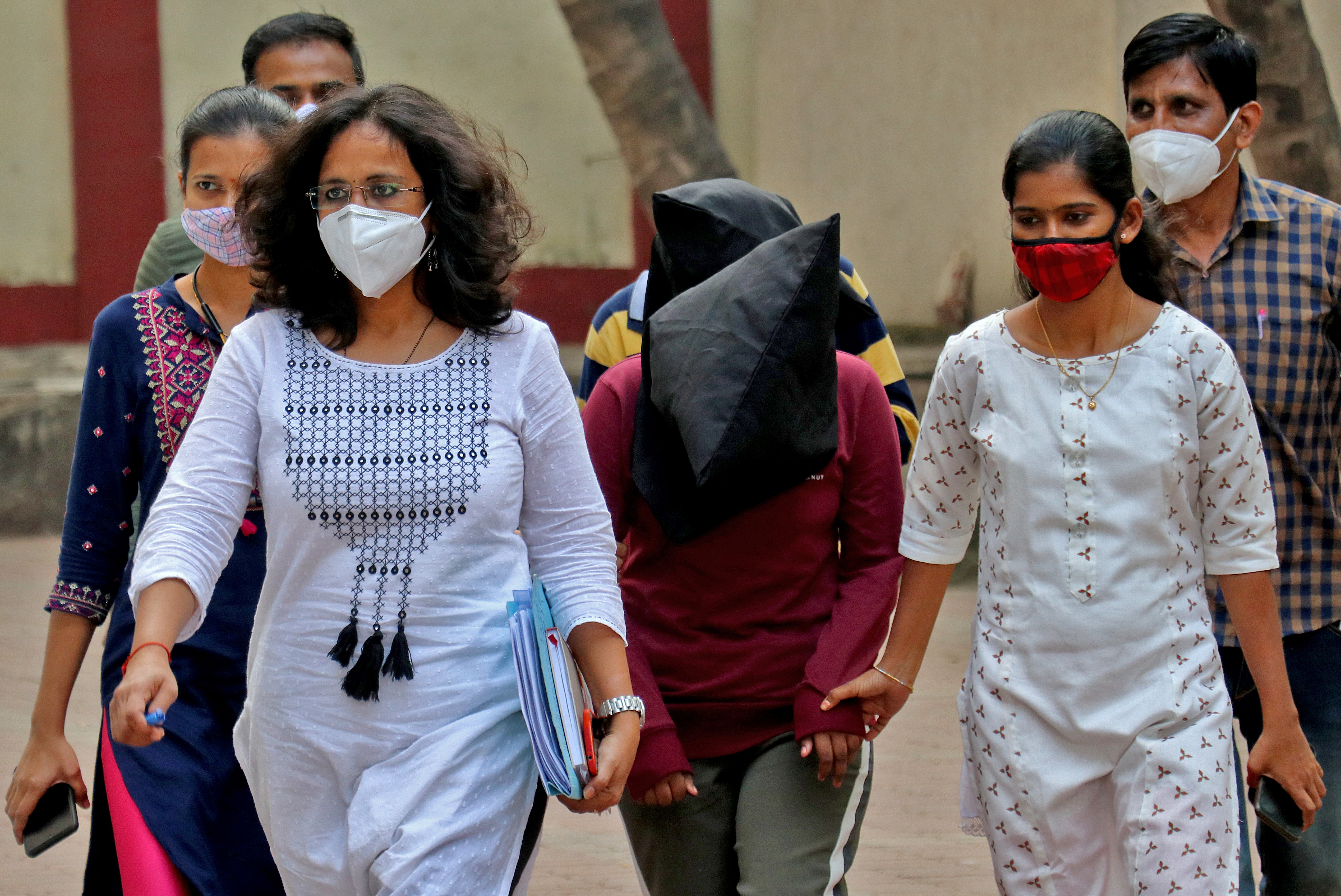 Police escort woman and man accused of involvement in online abuse in Mumbai