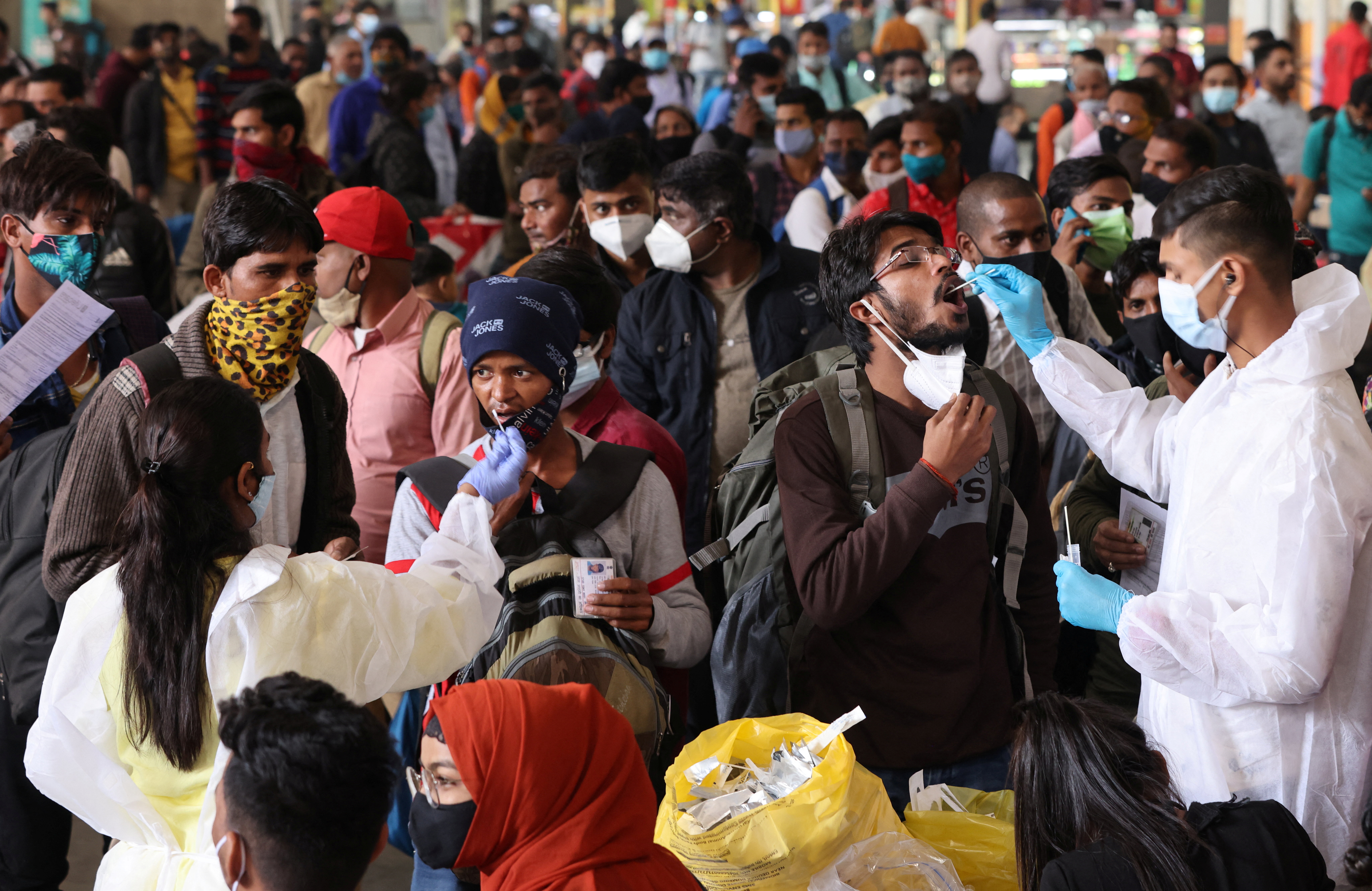Health workers collect swab samples during a rapid antigen testing campaign for coronavirus disease (COVID-19), at a railway station in Mumbai