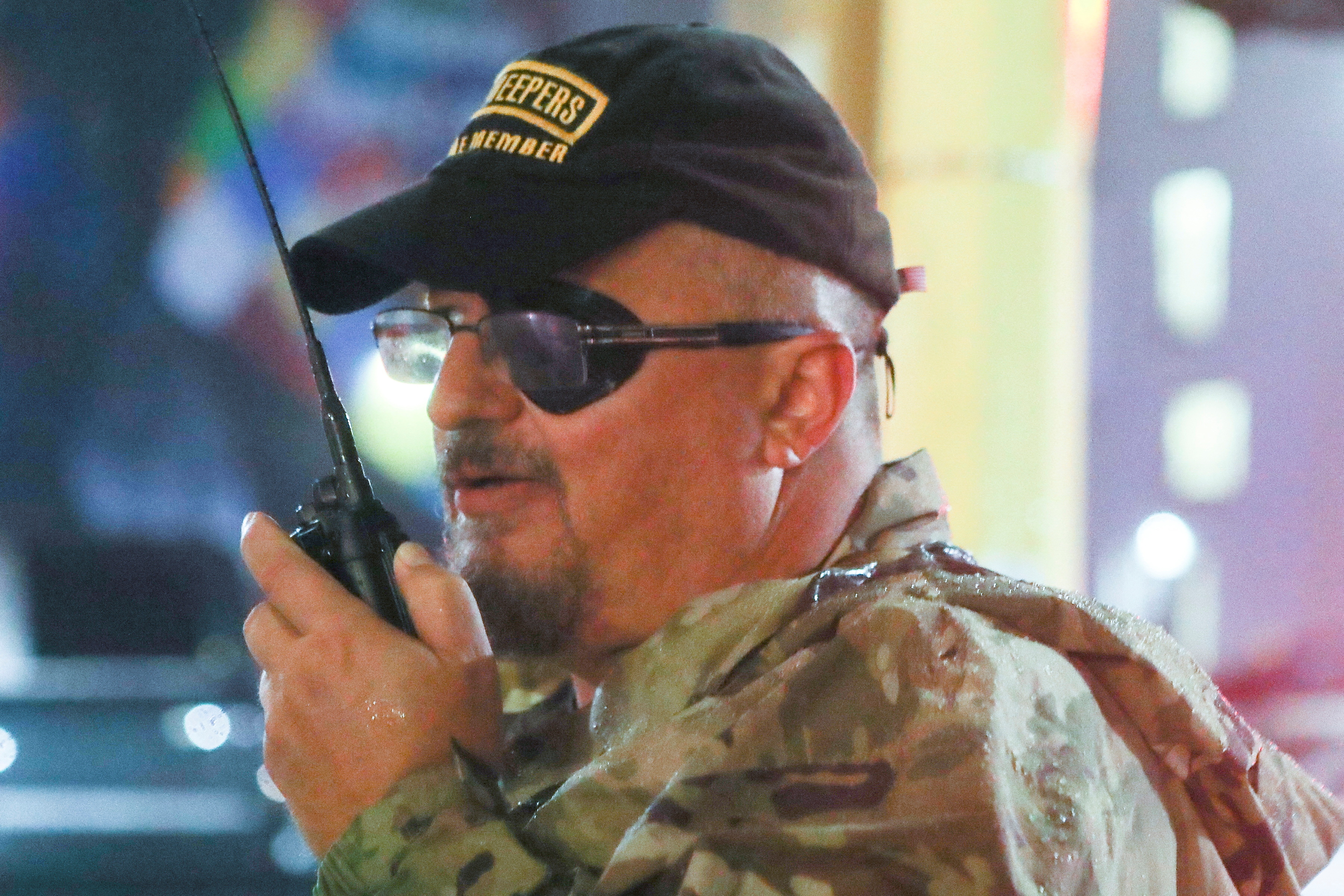 Stewart Rhodes uses a radio as he departs a rally in the US in 2019