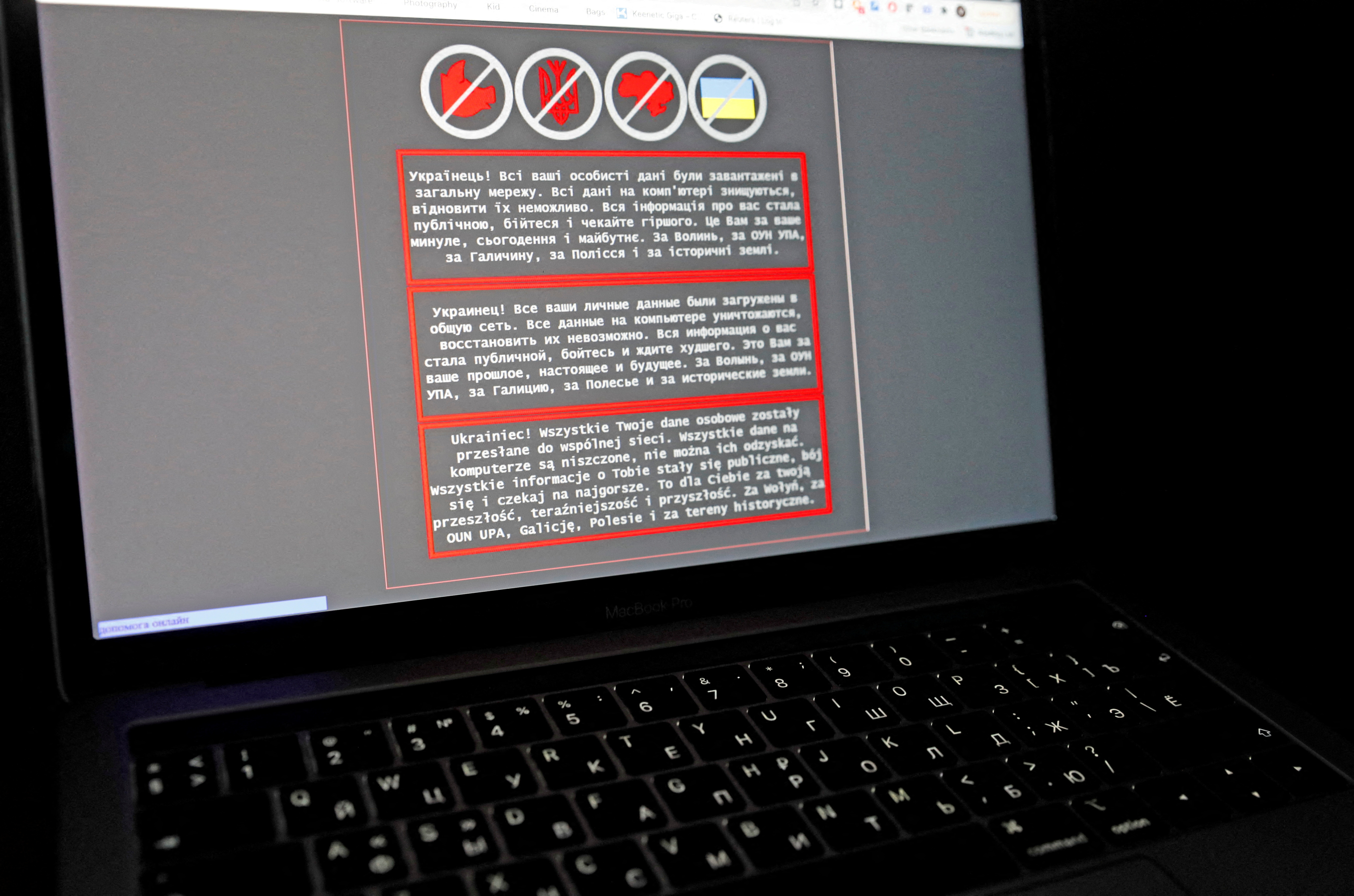 A laptop screen displays a warning message in Ukrainian, Russian and Polish, that appeared on the official website of the Ukrainian Foreign Ministry after a massive cyberattack,