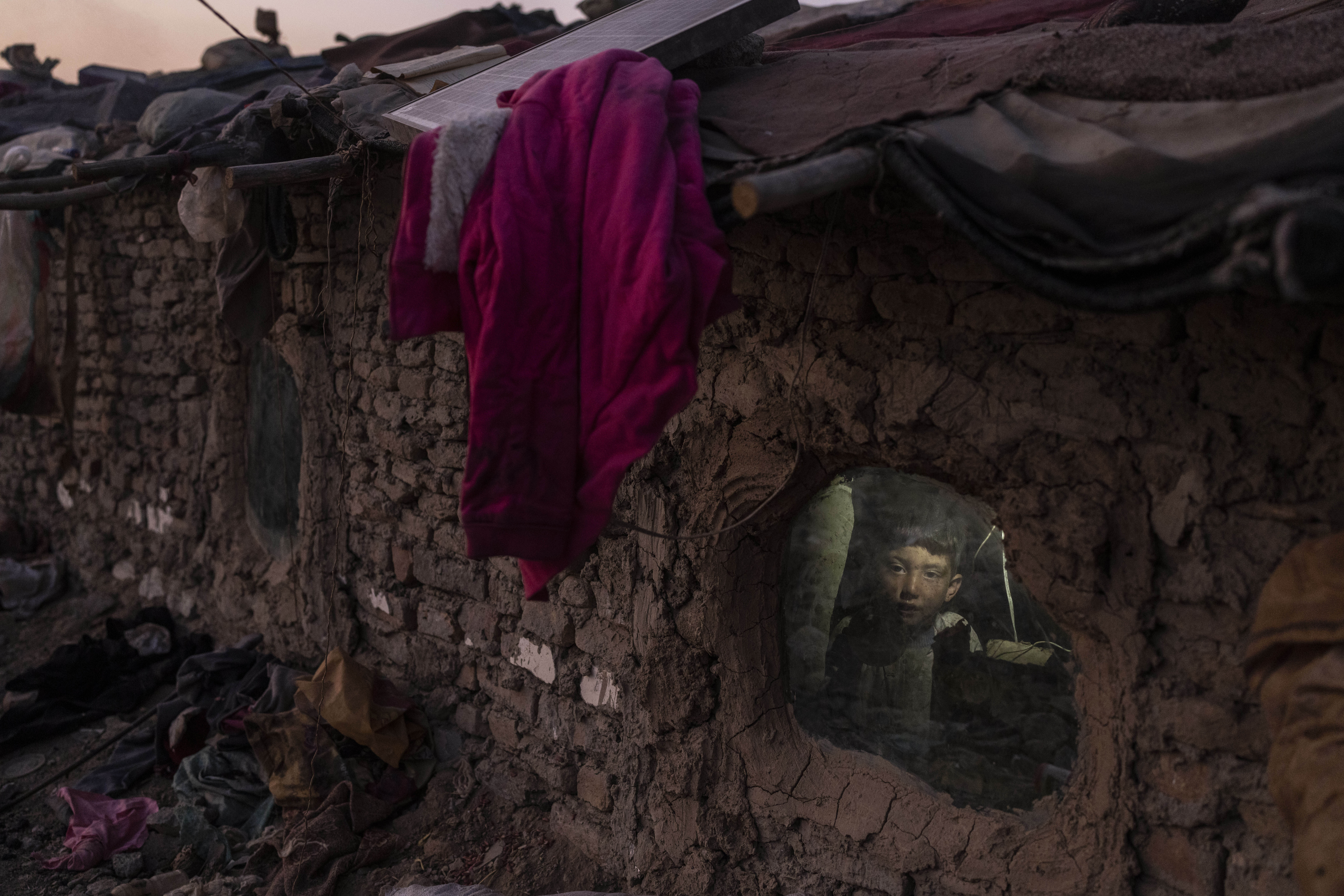 A child looks out a window of his home in Kabul