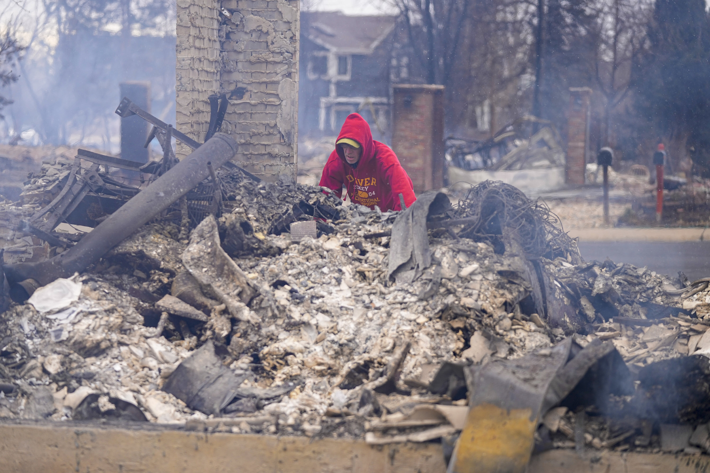 A resident looks through the rubble of his fire-damaged home in Colorado