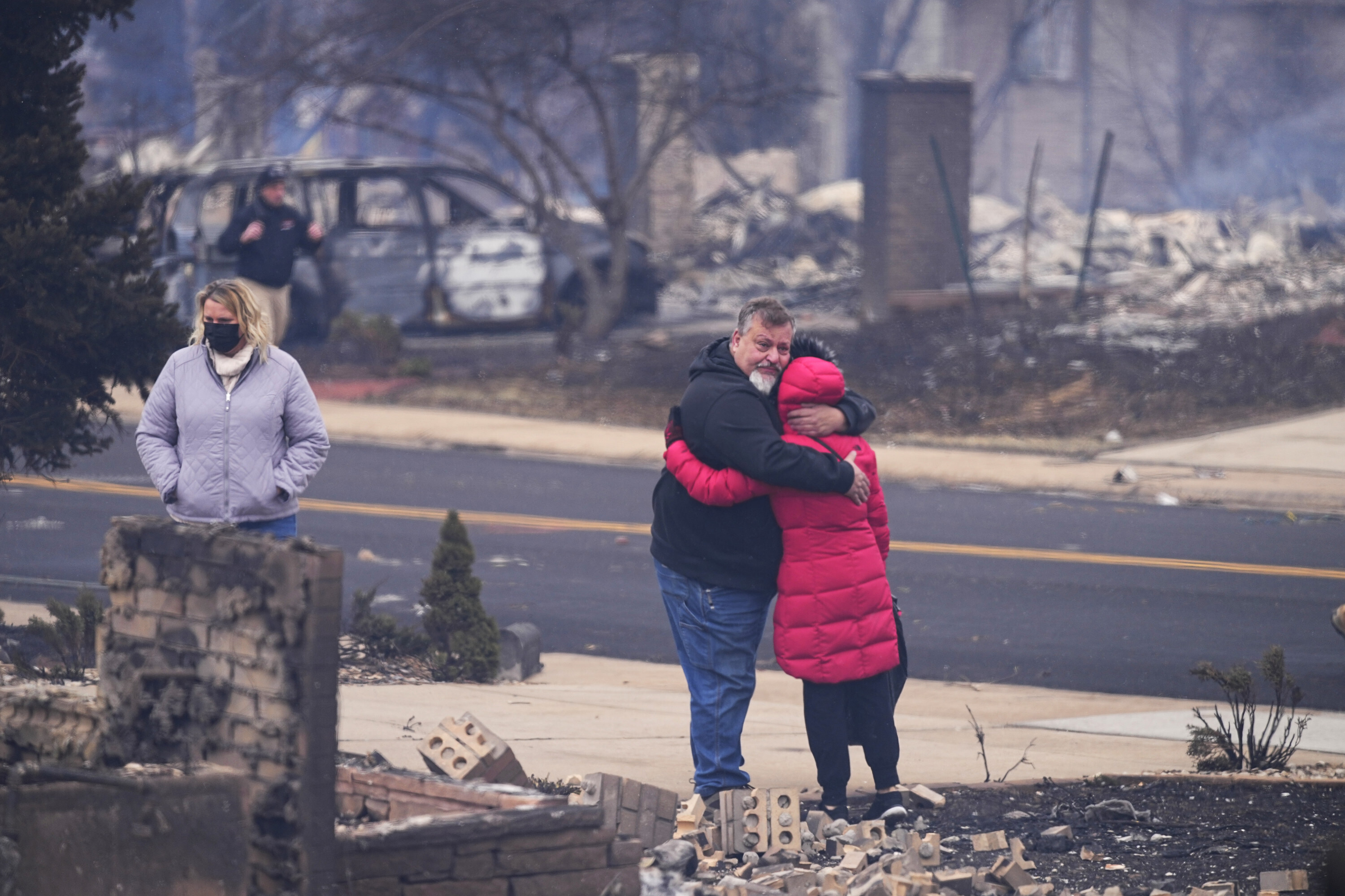 A man hugs his neighbour after finding their homes destroyed in Louisville, Colorado