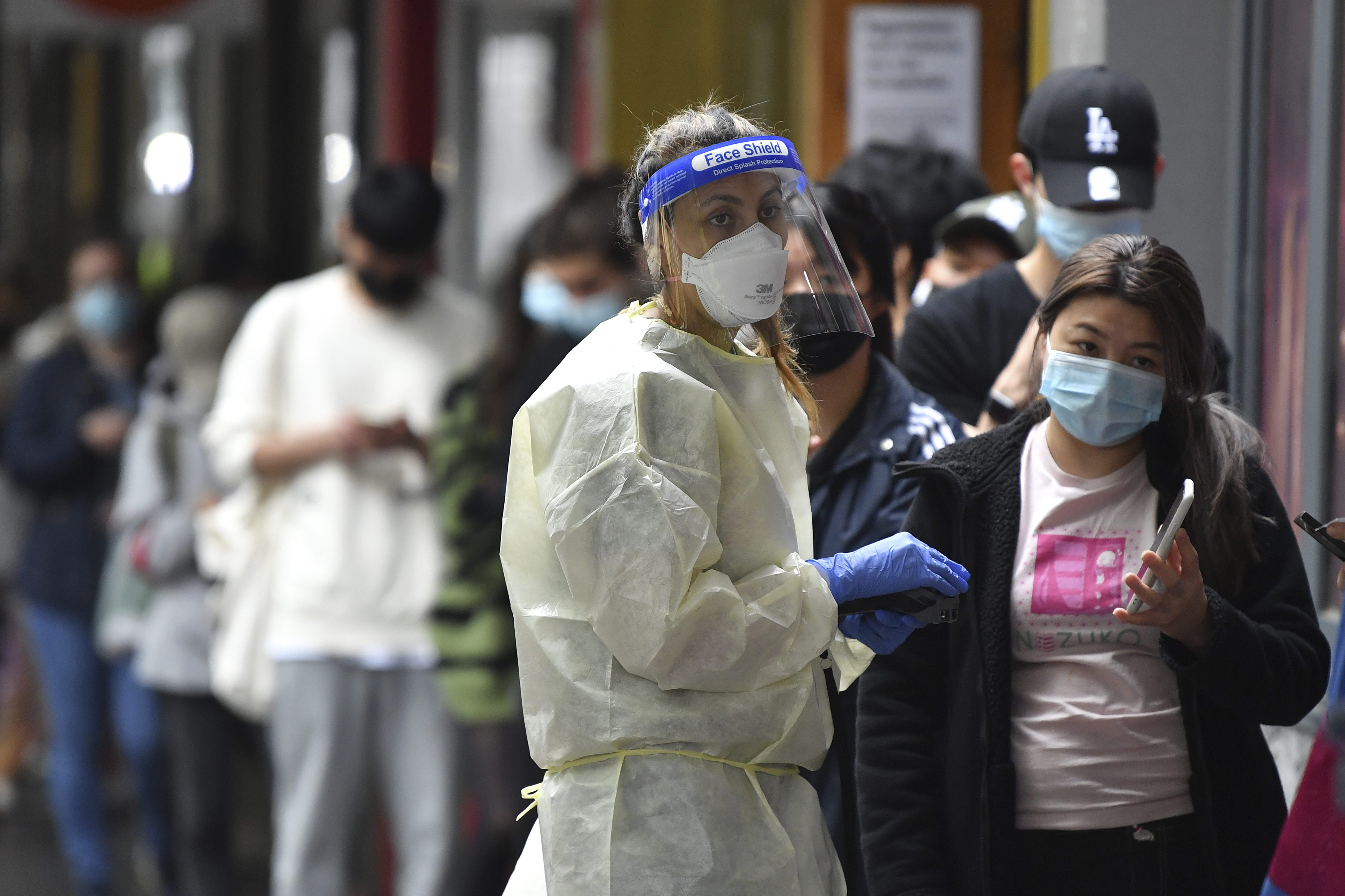 People queue at a walk-in COVID-19 testing site in Melbourne,, Australia