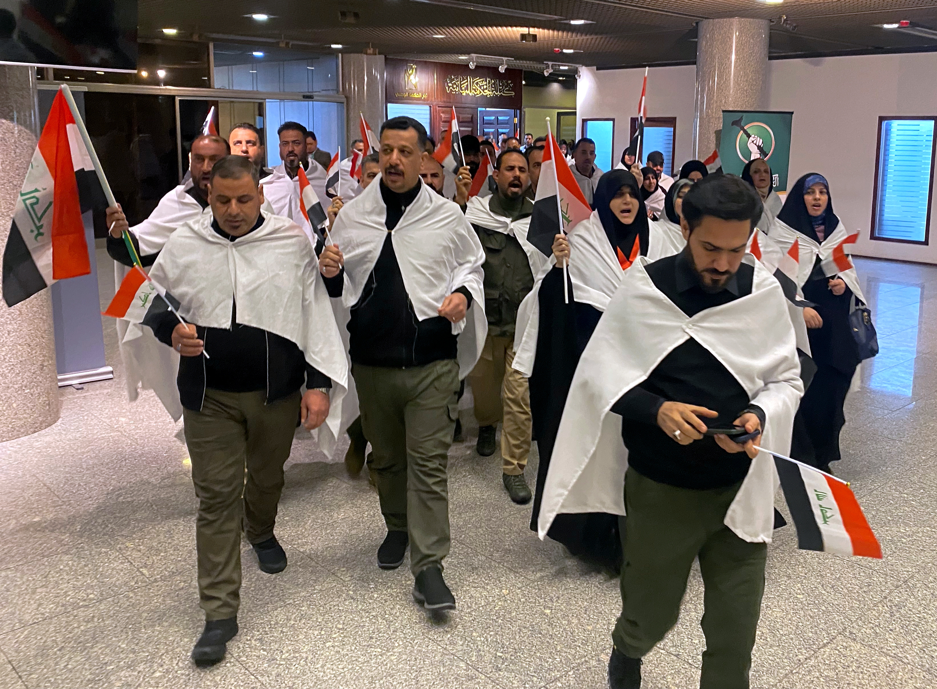Newly elected lawmakers from the al-Sadr political bloc prepare to attend the first parliament session, in Baghdad,