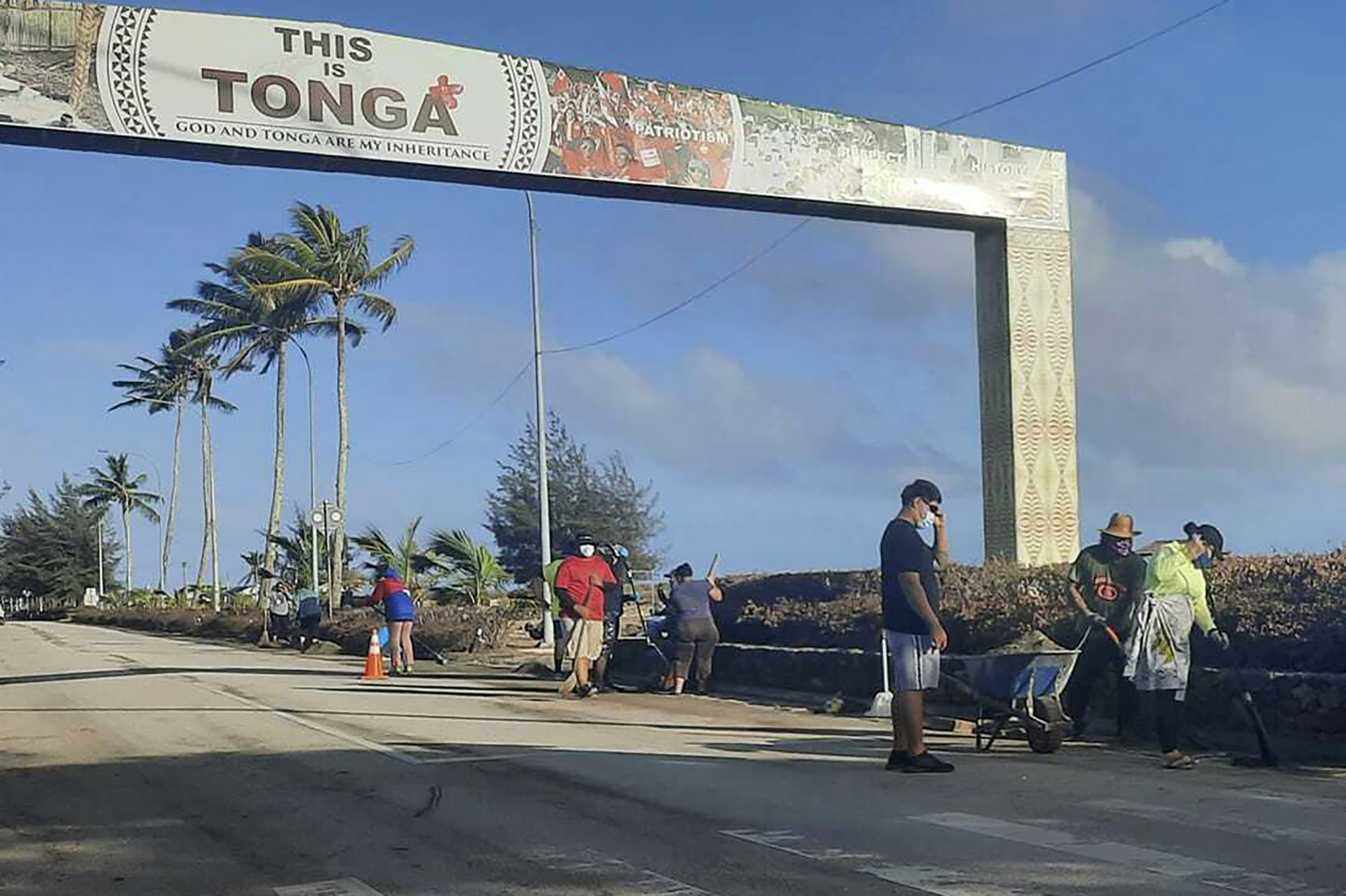 People clear debris off the street in Nuku'alofa, Tonga