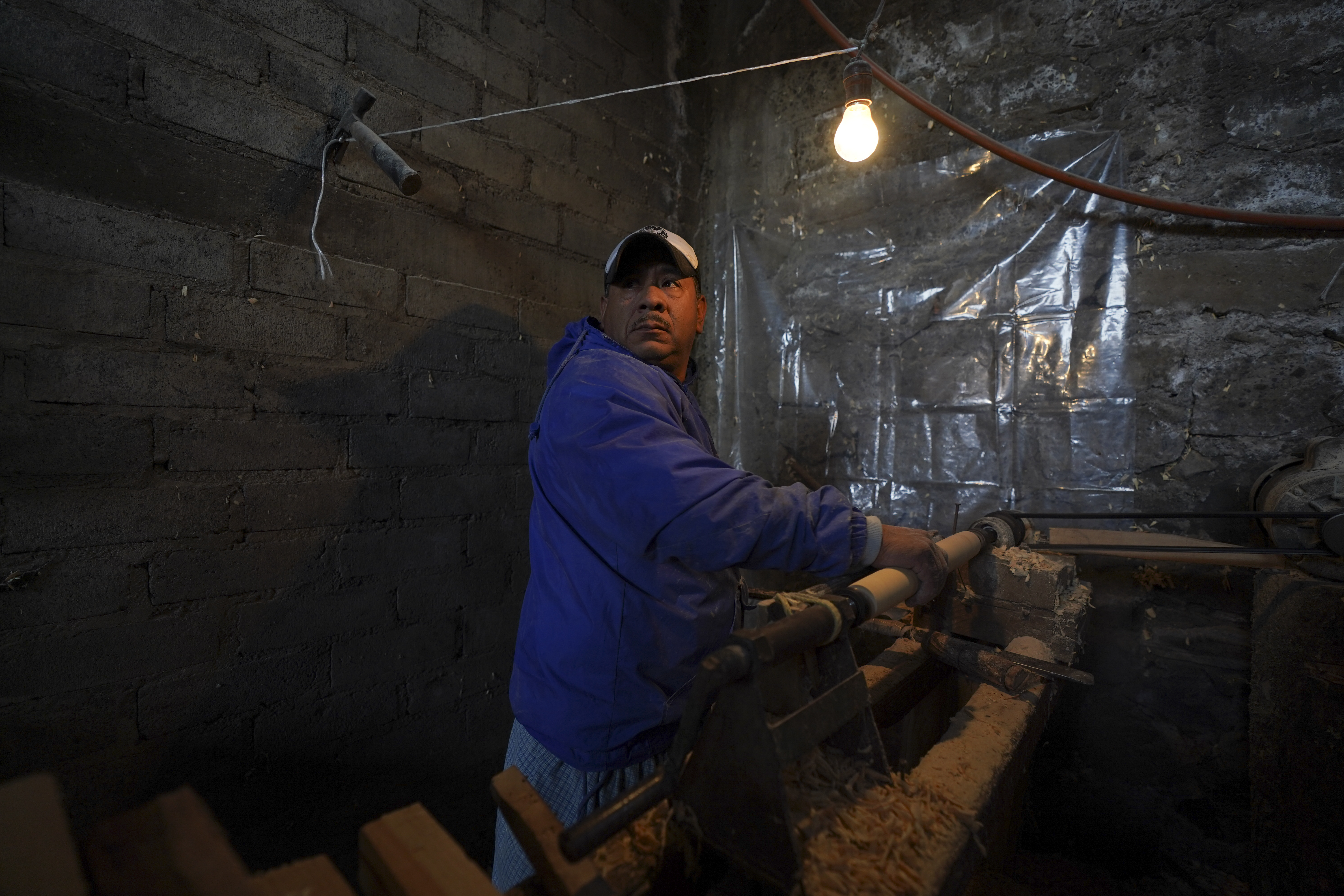 Tranquilino Gabriel works on decorative wood spindles on a primitive lathe using a nail-studded piece of wood, in the Puerpecha Indigenous community of Comachuen