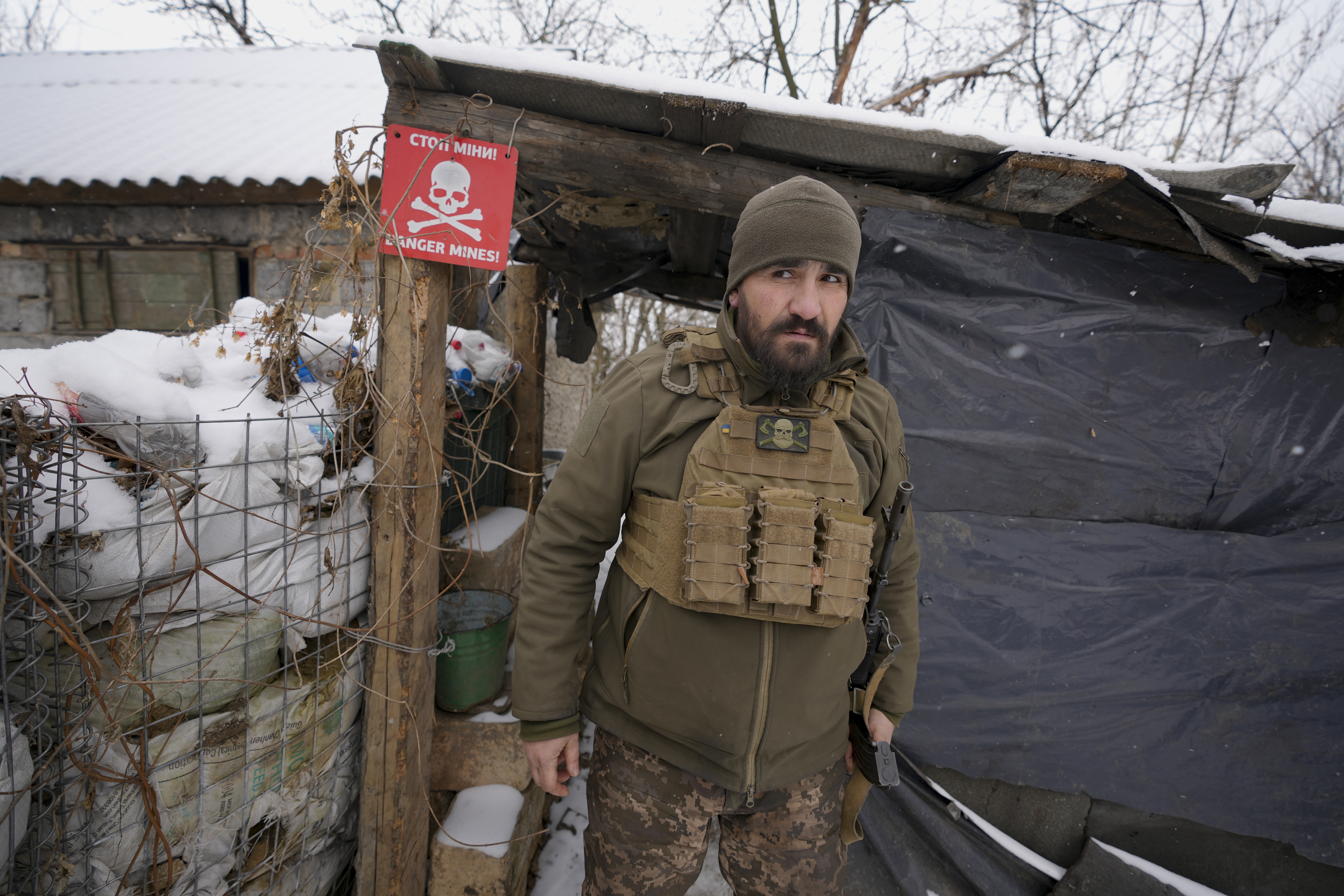 An Ukrainian serviceman looks around as he leaves a shelter on the front line in the Luhansk region, eastern Ukraine, Friday, Jan. 28, 2022.