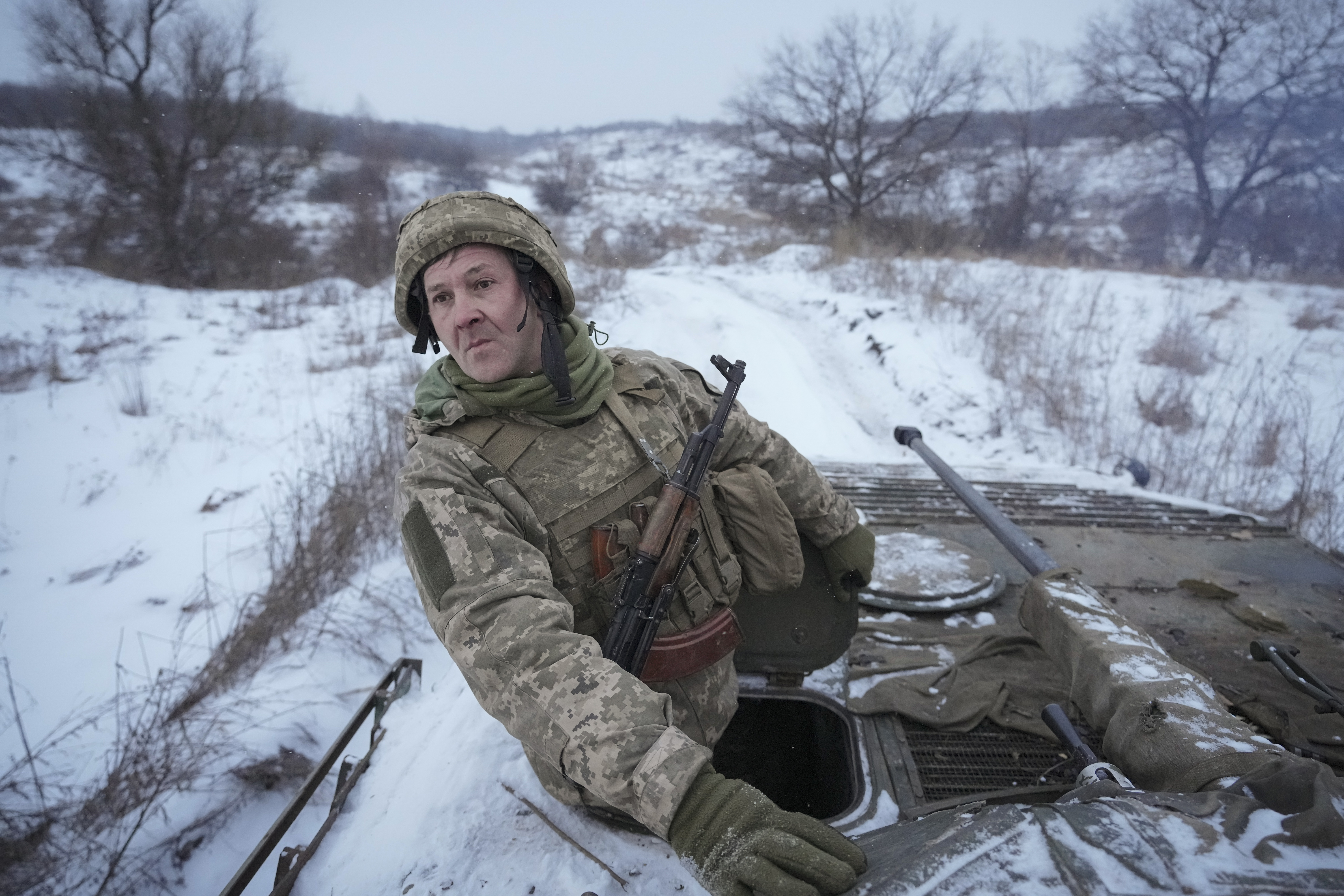 A Ukrainian serviceman looks back from atop an armored personnel carrier driving near a front line position in the Luhansk area, eastern Ukraine