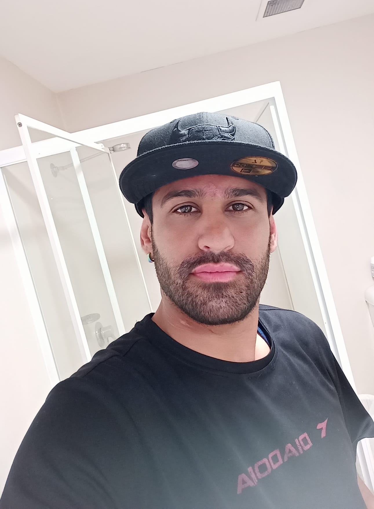 A selfie of a bearded Amin Afravi wearing a black t-shirt and black cap.